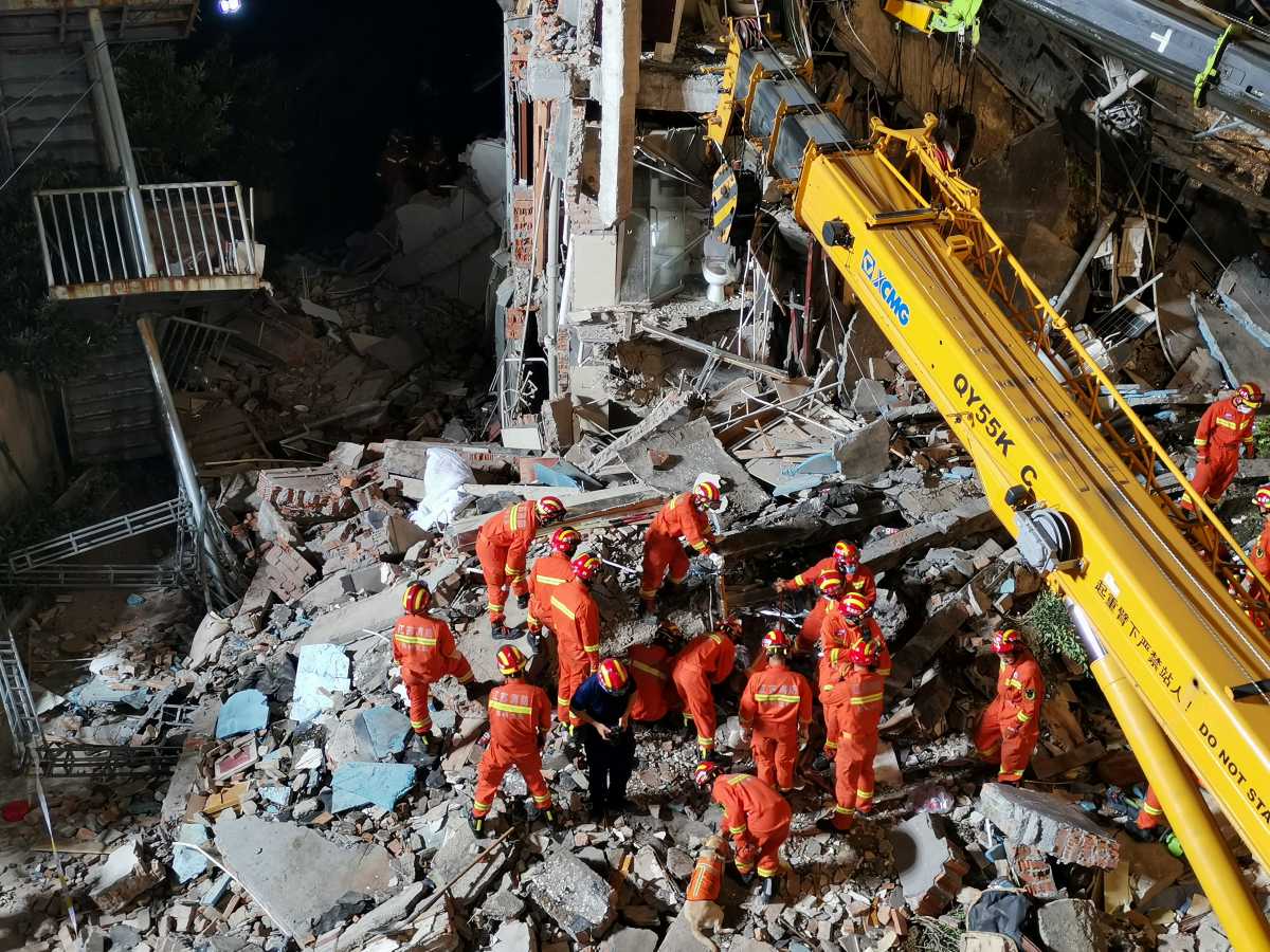 Rescue workers work next to a crane at the site where a hotel building collapsed in Suzhou, Jiangsu province, China July 12, 2021. Picture taken July 12, 2021. cnsphoto via REUTERS ATTENTION EDITORS - THIS IAGE WAS PROVIDED BY A THIRD PARTY. CHINA OUT.