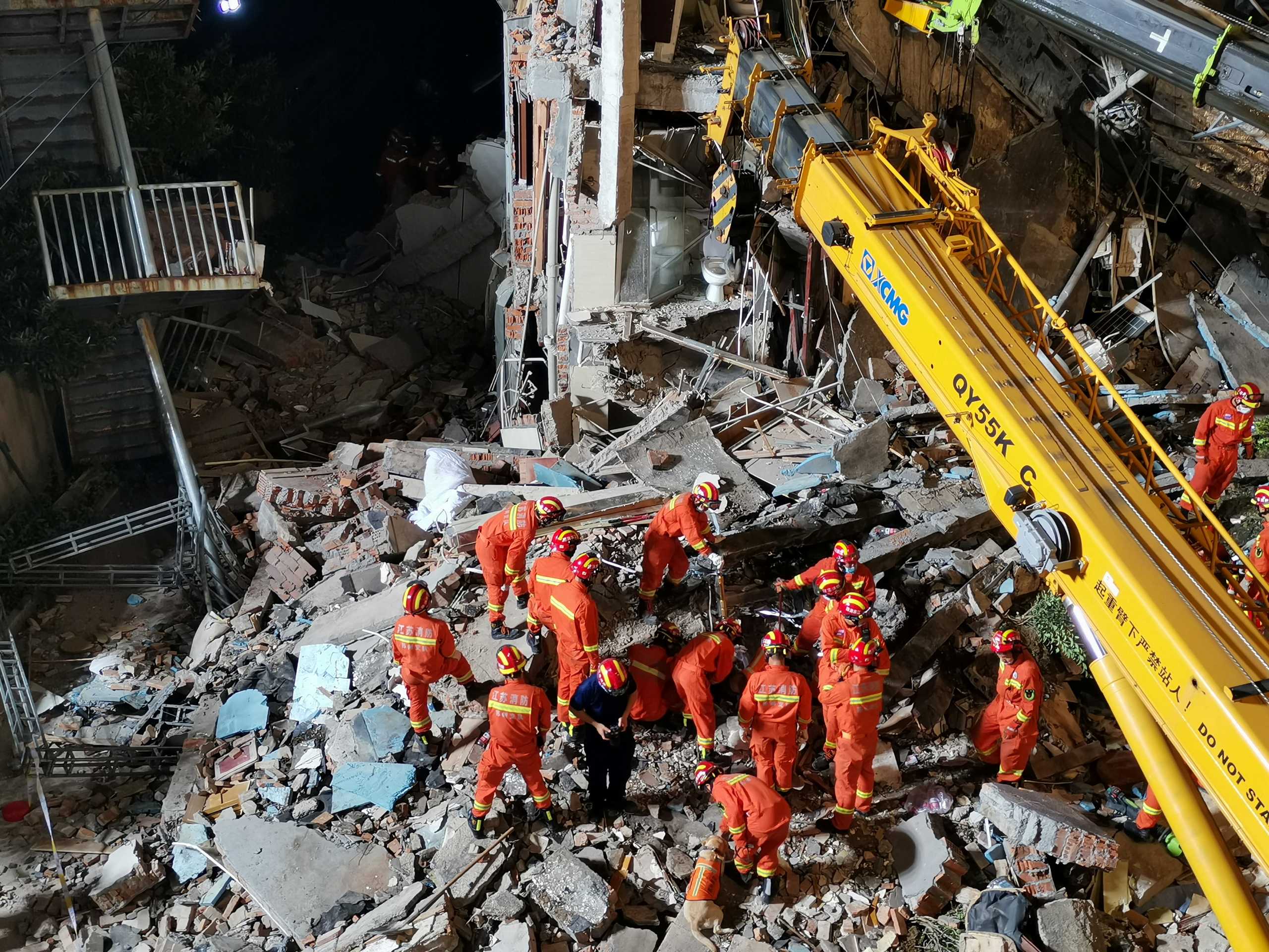 Rescue workers work next to a crane at the site where a hotel building collapsed in Suzhou, Jiangsu province, China July 12, 2021. Picture taken July 12, 2021. cnsphoto via REUTERS ATTENTION EDITORS - THIS IAGE WAS PROVIDED BY A THIRD PARTY. CHINA OUT.