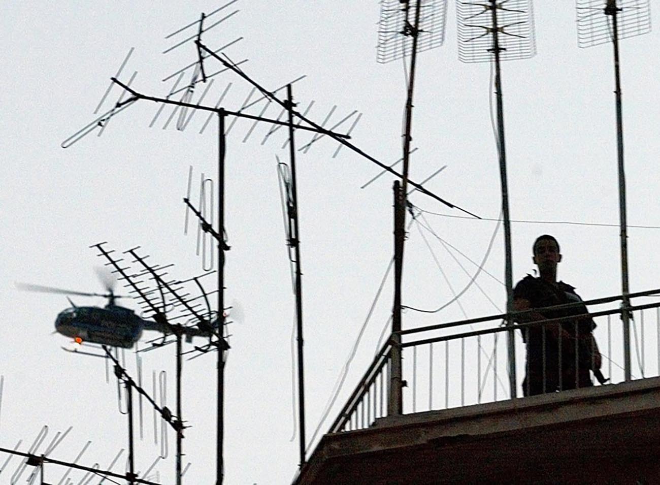 ATH06 - 20020703 - ATHENS, GREECE : Special police guard the scene as a police helicopter hovers over buildings in Athens after Greek police launched an anti-terrorist operation Wednesday 03 July 2002. Police led by an anti-terrorist unit surrounded a building near the city centre where they believe material used by November 17 has been stored, a police source said. The November 17 group is believed to be responsible for 23 killings beginning with the assassination of the CIA's Athens bureau head in 1975, with the most recent presumed attack occurring in 2000, when the British military attache in Athens was assassinated.  EPA PHOTO  EPA