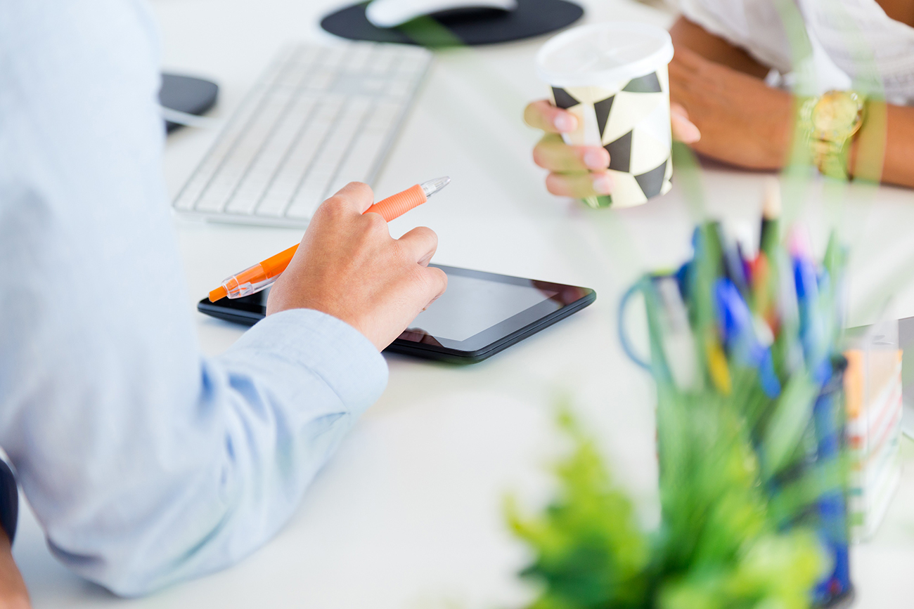 Portrait of two business woman working in office with digital tablet.