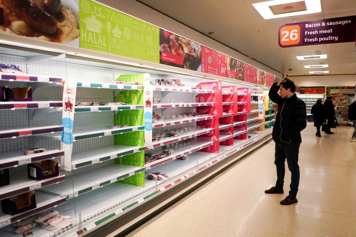 FILE PHOTO: A man stands next to shelves empty of fresh meat in a supermarket, as the number of worldwide coronavirus cases continues to grow,  in London, Britain, March 15, 2020. REUTERS