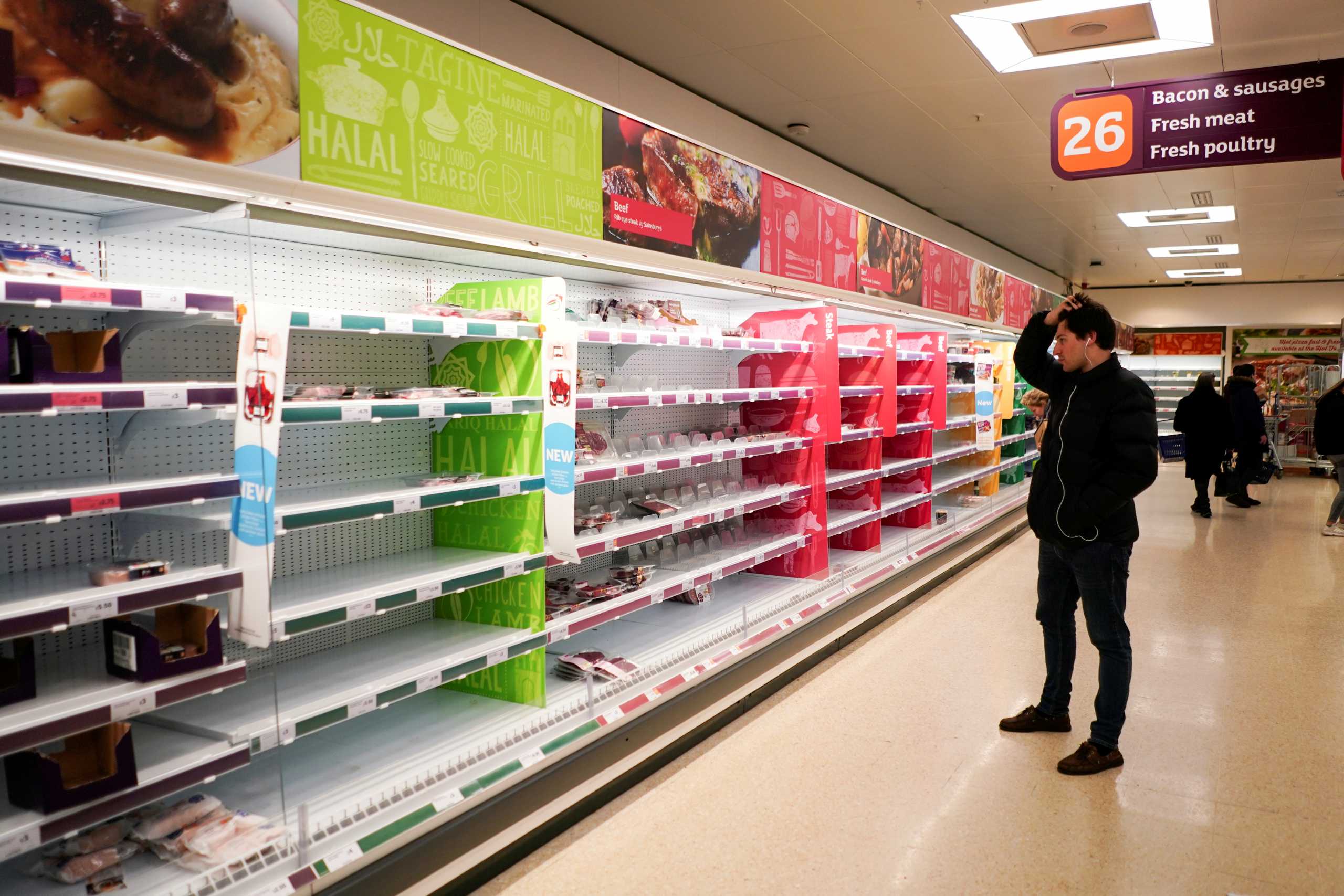 FILE PHOTO: A man stands next to shelves empty of fresh meat in a supermarket, as the number of worldwide coronavirus cases continues to grow,  in London, Britain, March 15, 2020. REUTERS