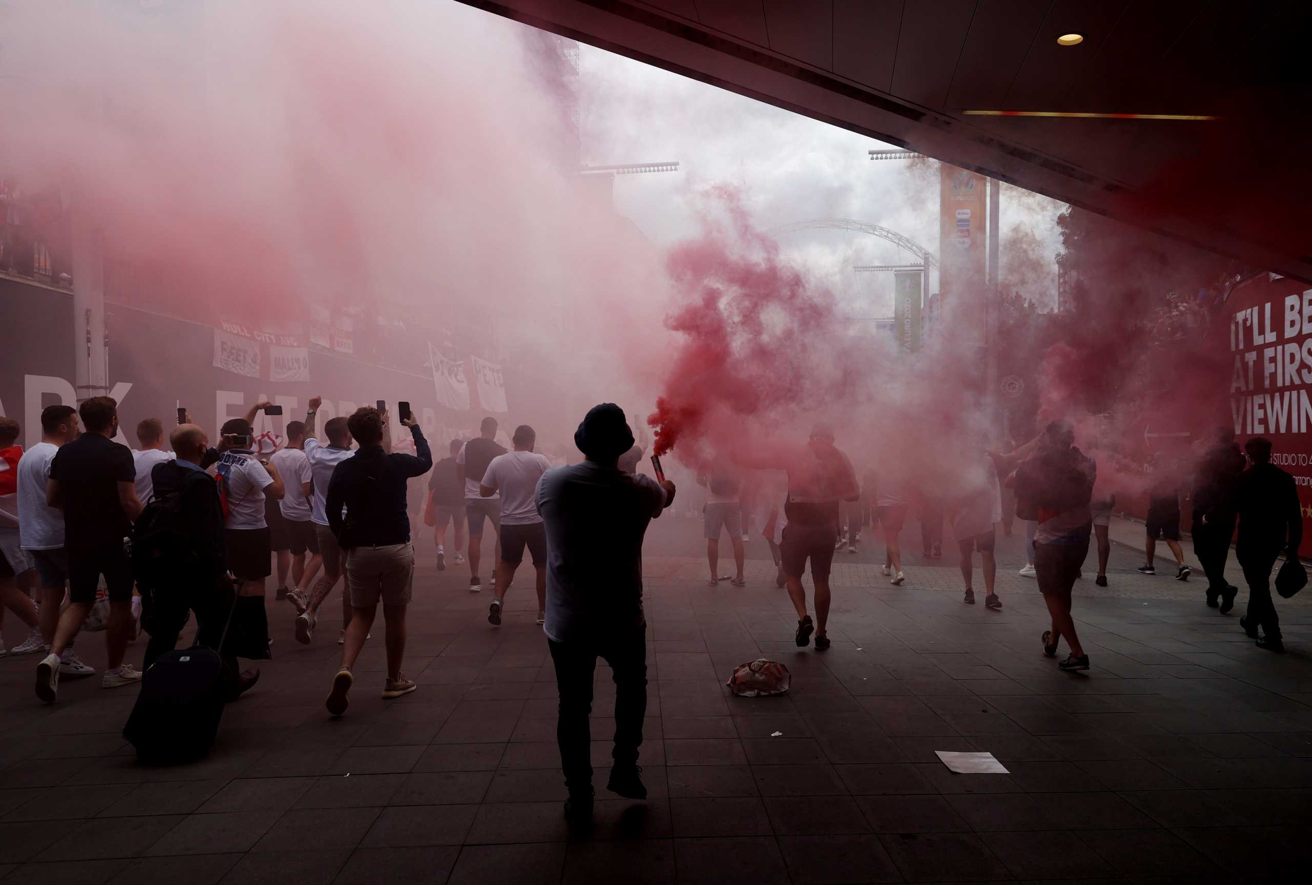 Soccer Football - Euro 2020 - Fans gather for Italy v England - Wembley Stadium, London, Britain - July 11, 2021 England fans with flares on Wembley way outside Wembley stadium ahead of the match Action Images via Reuters