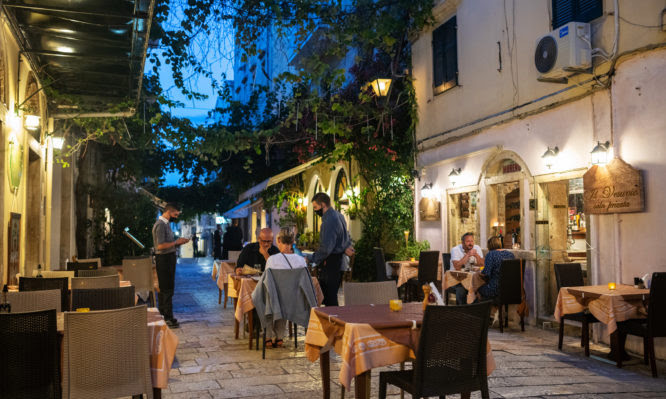 Corfu City, Greece October 02,2020: People sit in a restaurant and enjoy their dinner.