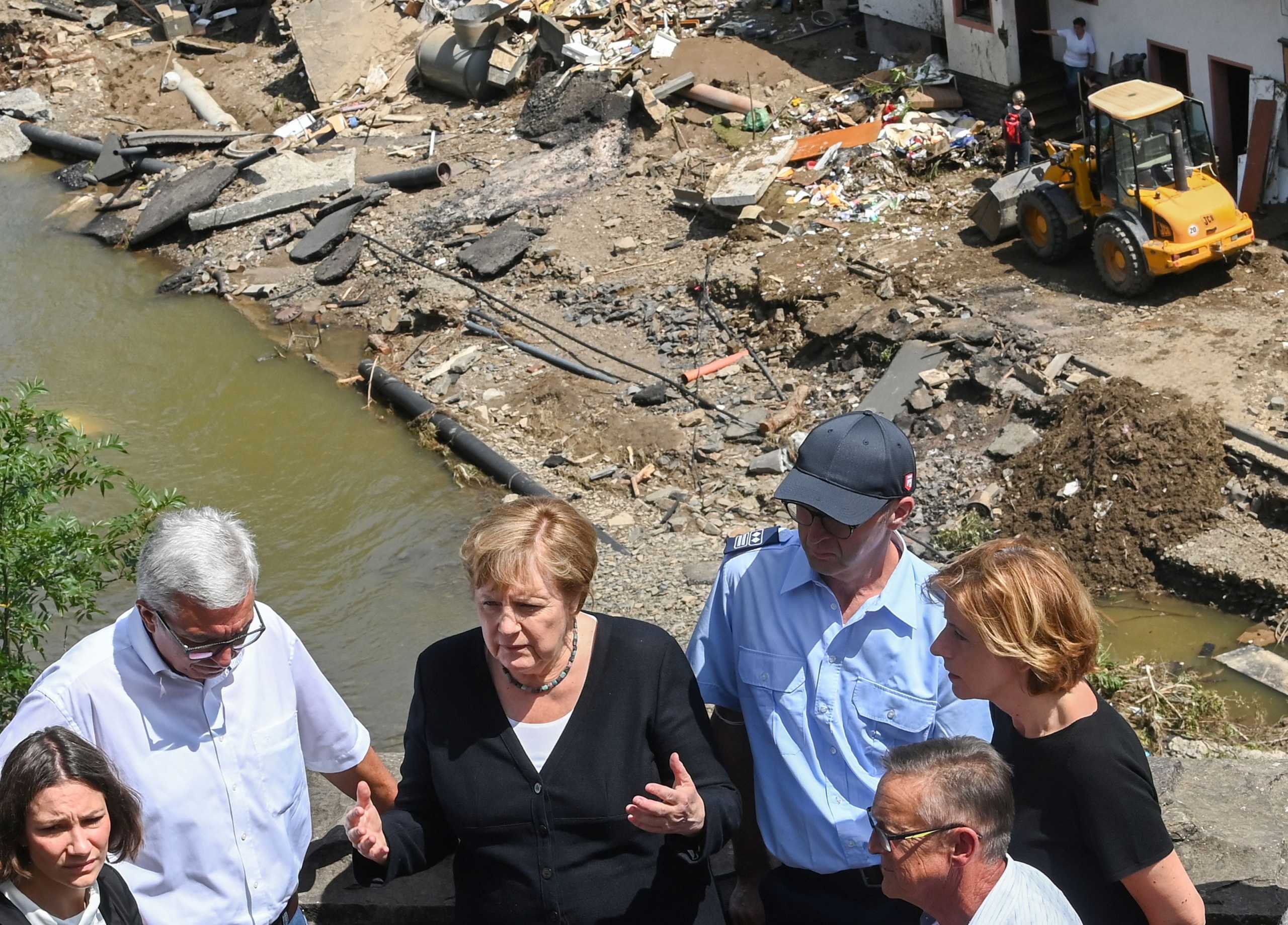 German Chancellor Angela Merkel (2nd L) and Rhineland-Palatinate State Premier Malu Dreyer (R) talk as they stand on a bridge during their visit in the flood-ravaged areas in Schuld near Bad Neuenahr-Ahrweiler, Rhineland-Palatinate state, Germany July 18, 2021. Christof Stache
