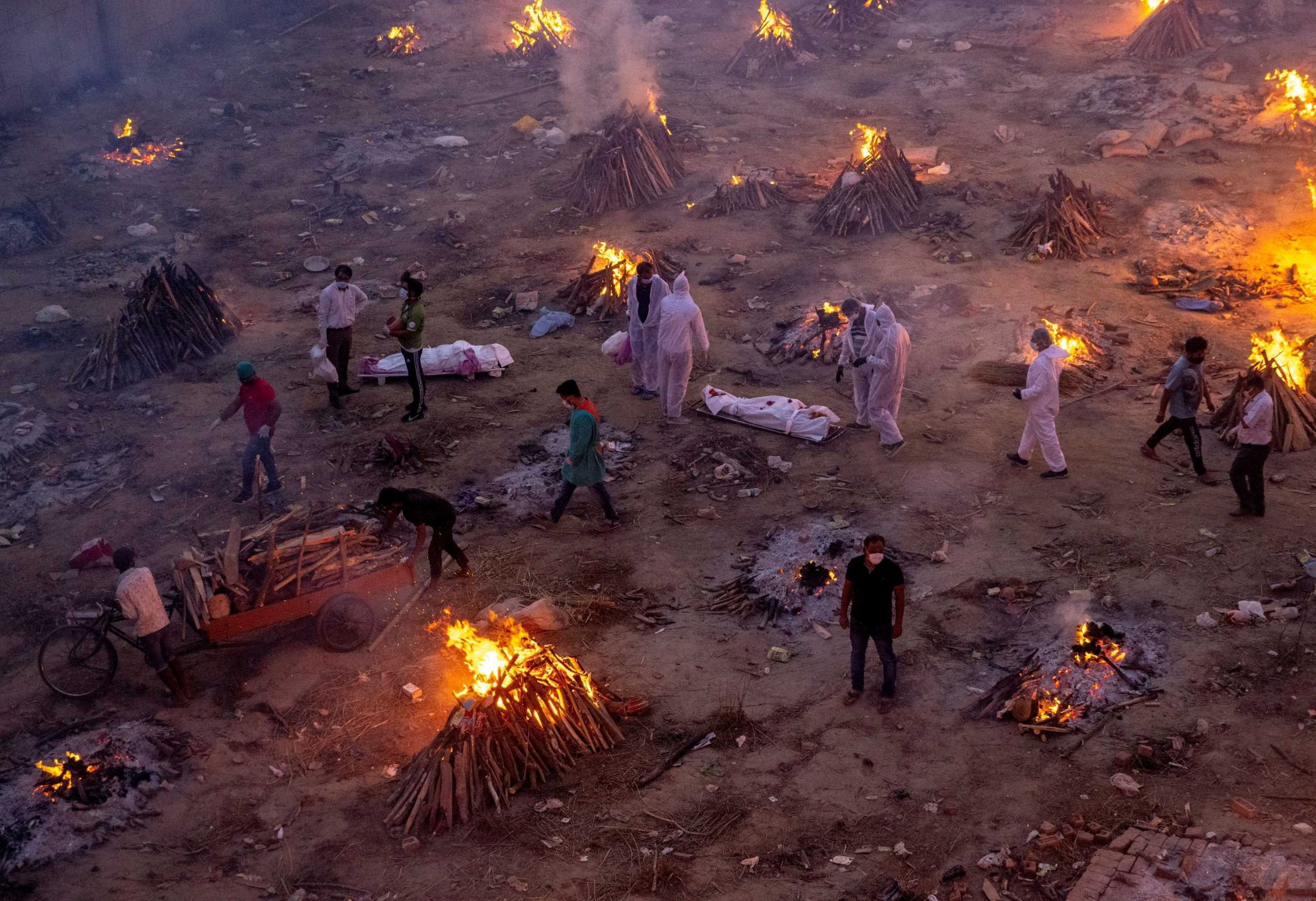 FILE PHOTO: People wait to cremate victims who died due to the coronavirus disease (COVID-19), at a crematorium ground in New Delhi, India, April 23, 2021. REUTERS