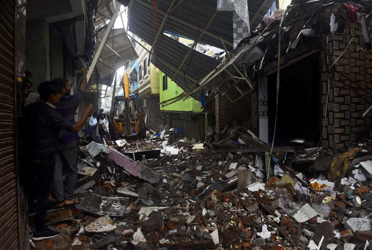 People use their mobile phones to take pictures of a collapsed building following rains in Mumbai, India, July 23, 2021. REUTERS
