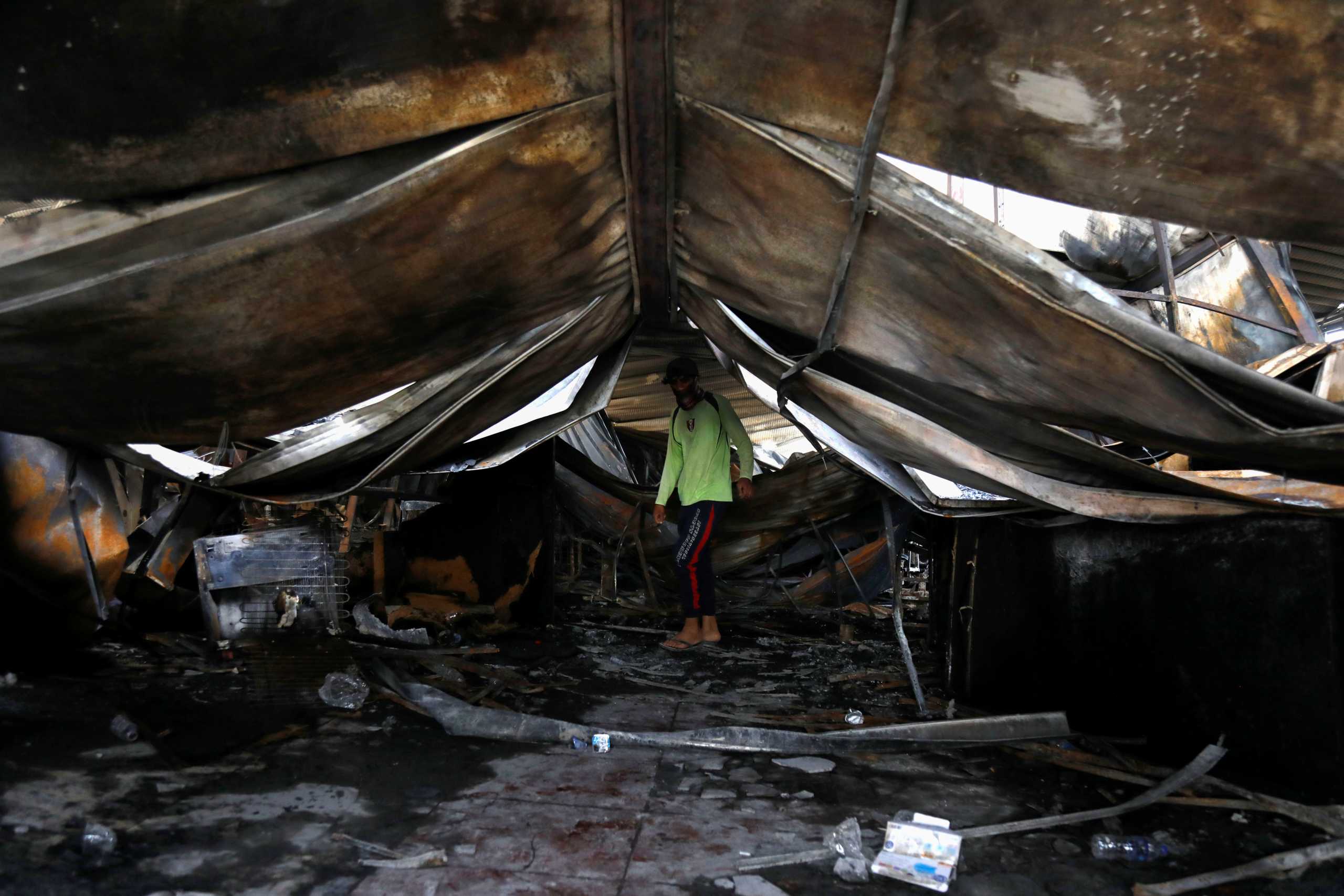 A man inspects the damage at al-Hussain coronavirus hospital where a fire broke out, in Nassiriya, Iraq, July 13, 2021. REUTERS