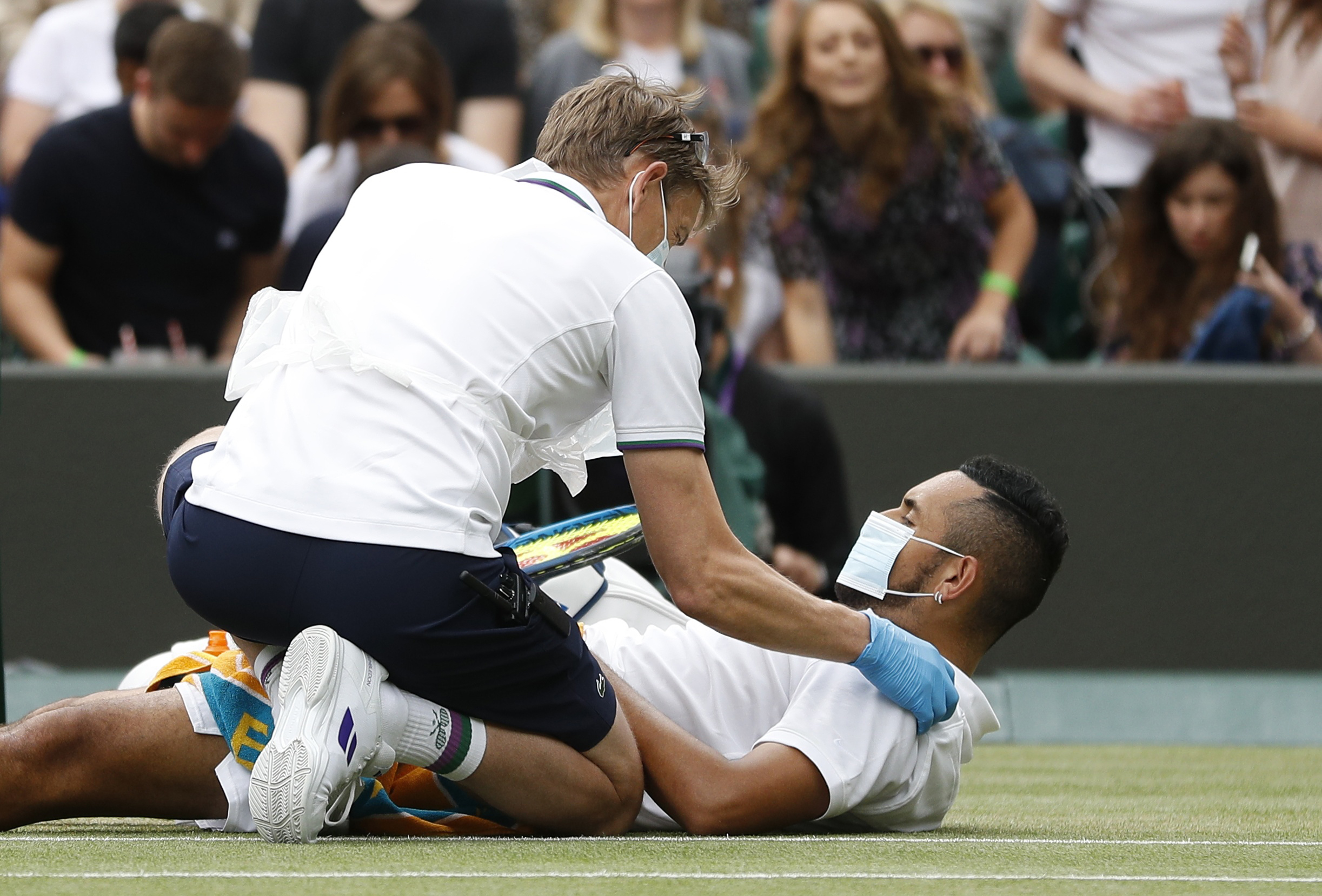 Tennis - Wimbledon - All England Lawn Tennis and Croquet Club, London, Britain - July 3, 2021  Australia's Nick Kyrgios receives medical treatment after sustaining an injury during his third round match against Canada's Felix Auger Aliassime REUTERS