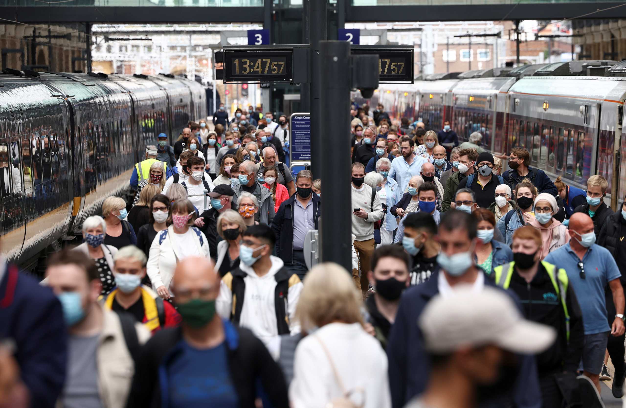 People wearing protective face masks walk along a platform at King's Cross Station, amid the coronavirus disease (COVID-19) outbreak in London, Britain, July 12, 2021. REUTERS