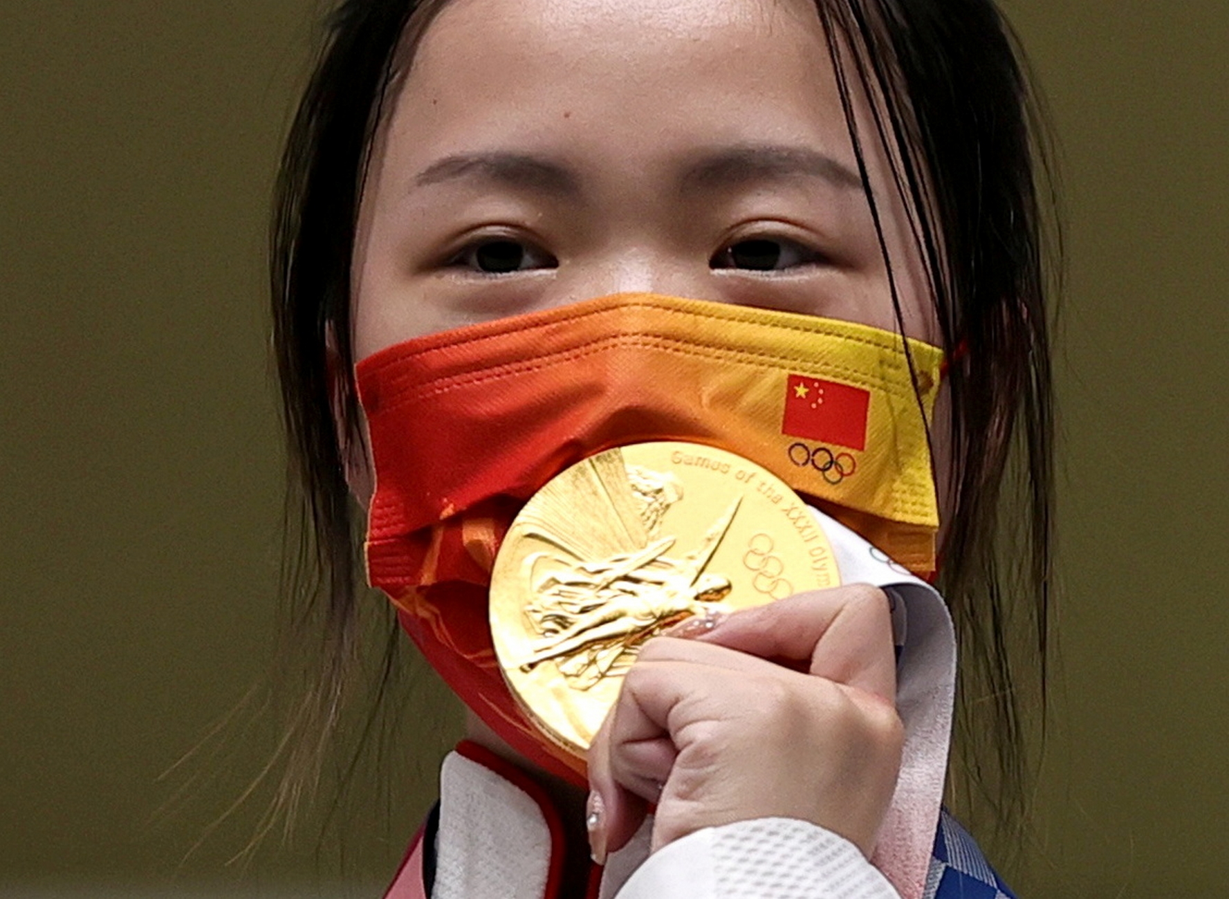 Tokyo 2020 Olympics - Shooting - Women's 10m Air Rifle - Medal Ceremony - Asaka Shooting Range, Tokyo, Japan – July 24, 2021. Gold medallist Yang Qian of China celebrates on the podium REUTERS