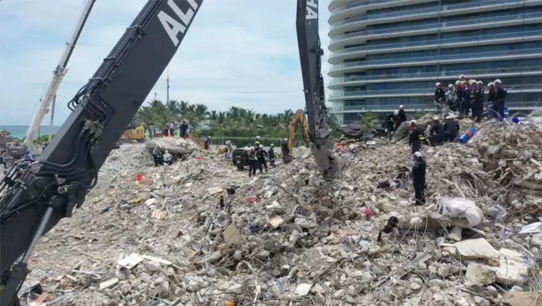 Search-and-rescue personnel work on the debris of the collapsed Champlain Towers South condominium in Surfside, Florida, U.S., July 5, 2021, in this still image obtained from video. Courtesy of  Miami-Dade Fire Rescue Department