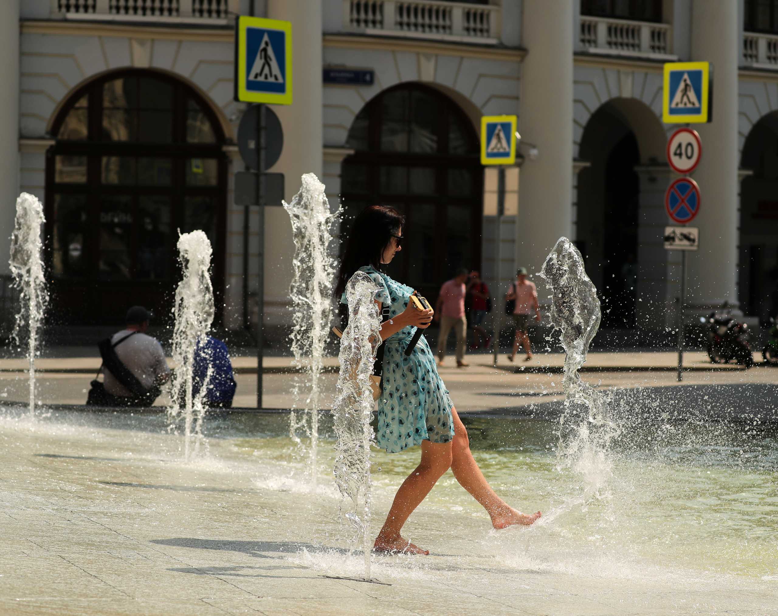 A woman wets her feet in a water fountain on a hot day in Moscow, Russia June 23, 2021. REUTERS