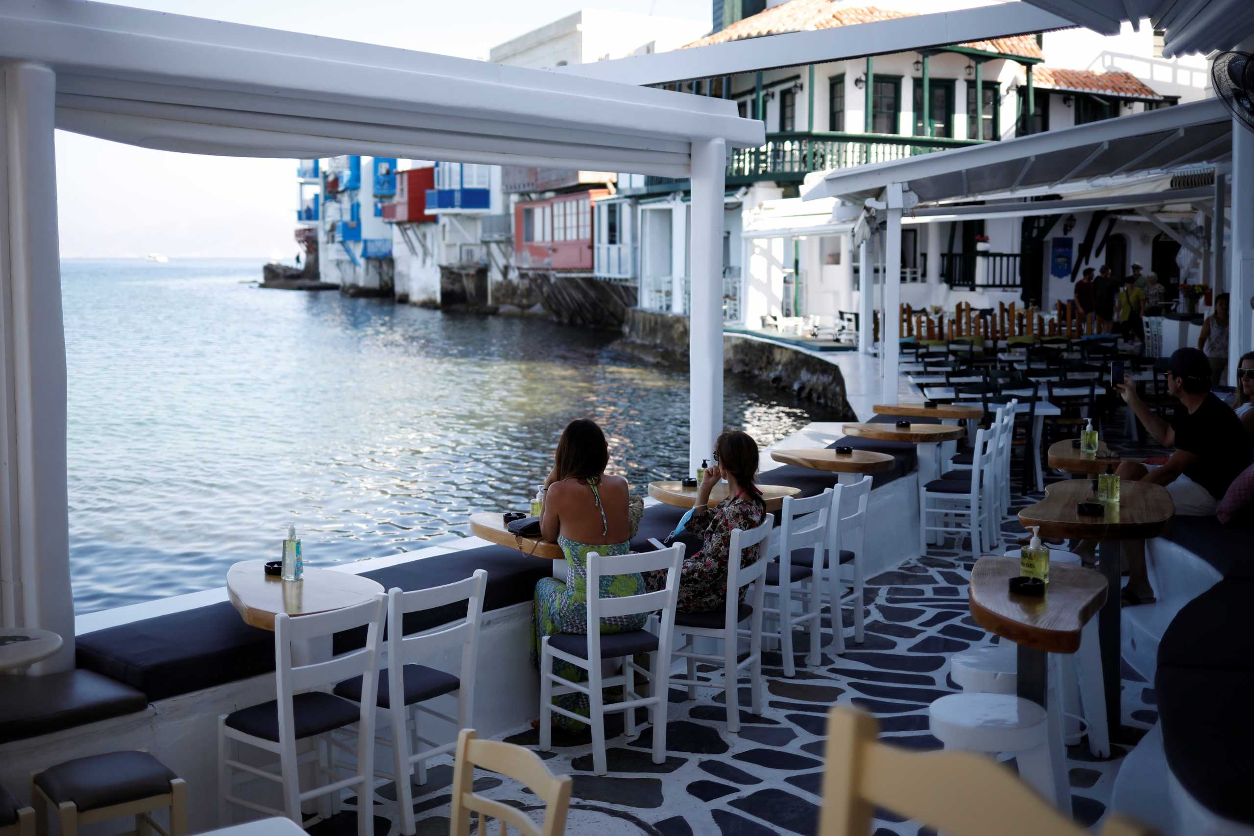 People enjoy the view in a cafe in Little Venice as Greece banned music in restaurants and bars and imposed a nighttime curfew on the island of Mykonos, Greece, July 18, 2021. REUTERS