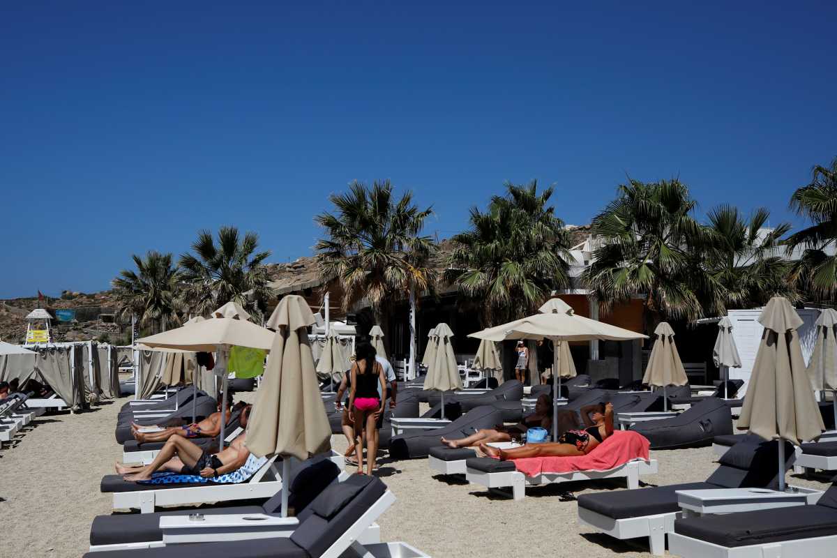People lay on sunbeds at the Tropicana beach bar in Paradise beach, as Greece banned music in restaurants and bars and imposed a nighttime curfew on the island of Mykonos, Greece, July 18, 2021. REUTERS