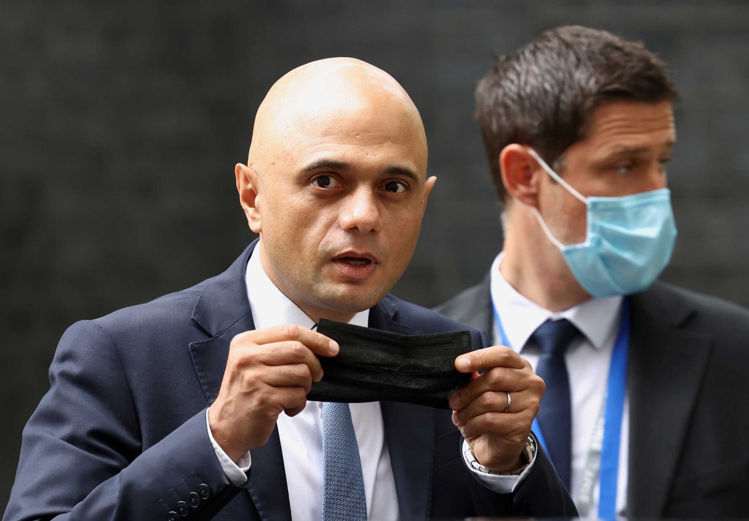 FILE PHOTO: Britain's new Health Secretary Sajid Javid holds a face mask, as he leaves the Downing Street in London, Britain, June 30, 2021. REUTERS