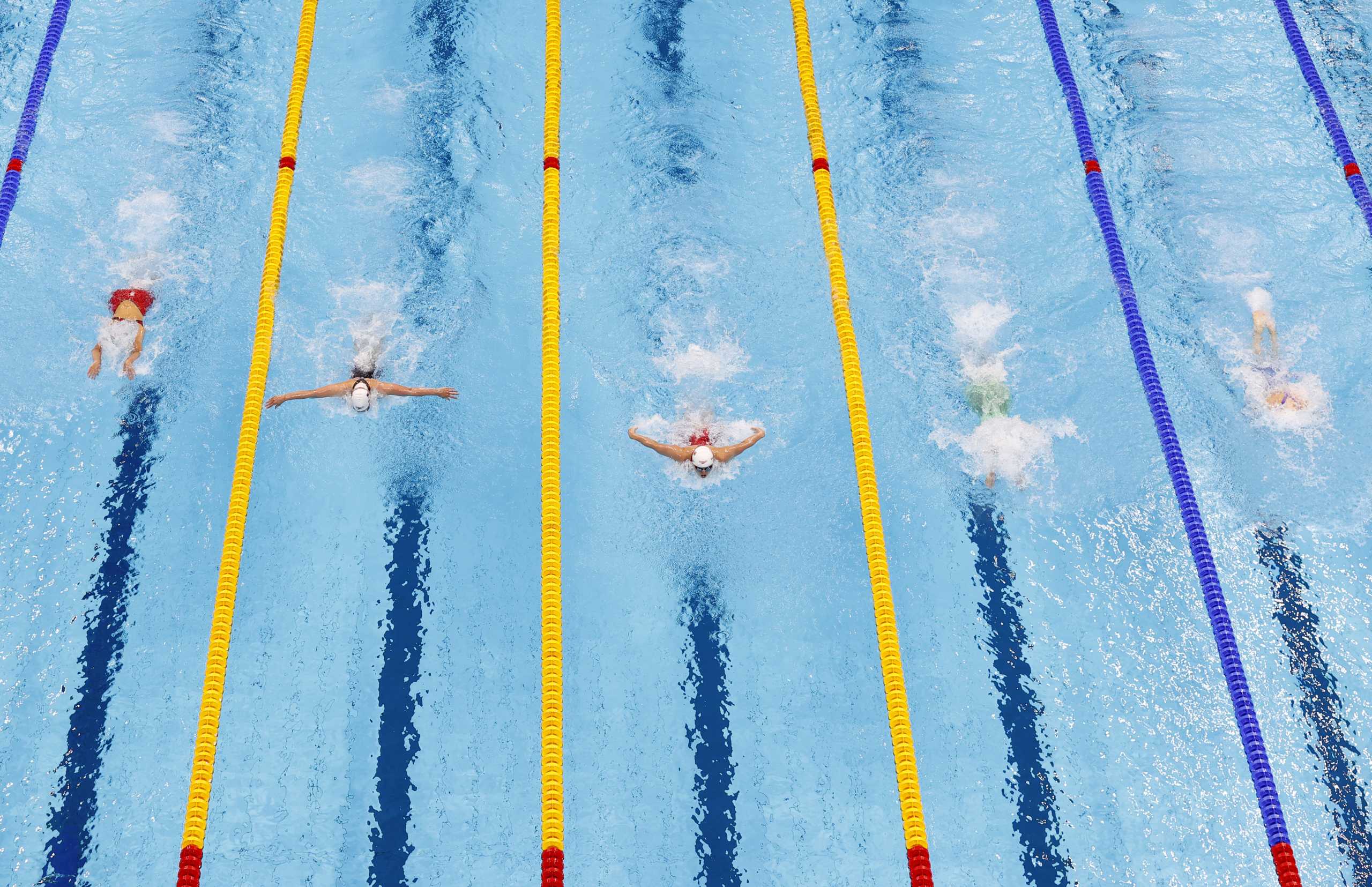 Tokyo 2020 Olympics - Swimming - Women's 100m Butterfly - Heats - Tokyo Aquatics Centre - Tokyo, Japan - July 24, 2021. Maggie MacNeil of Canada and others in action REUTERS