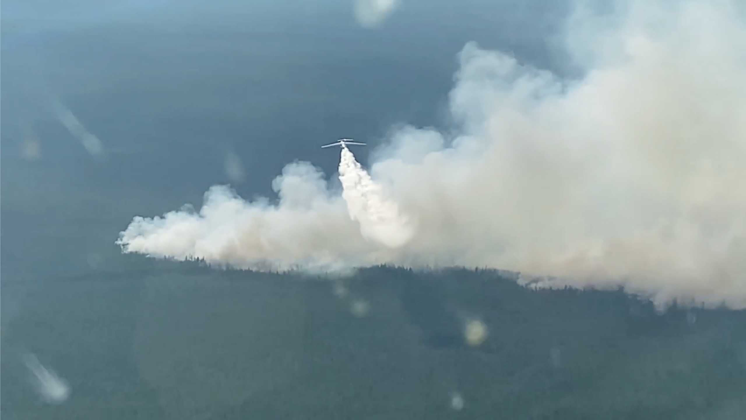 A plane makes a water drop to fight a forest fire in the region of Yakutia in eastern Siberia, Russia, in this still image taken from video released July 14, 2021. Ministry of Defence of the Russian Federation