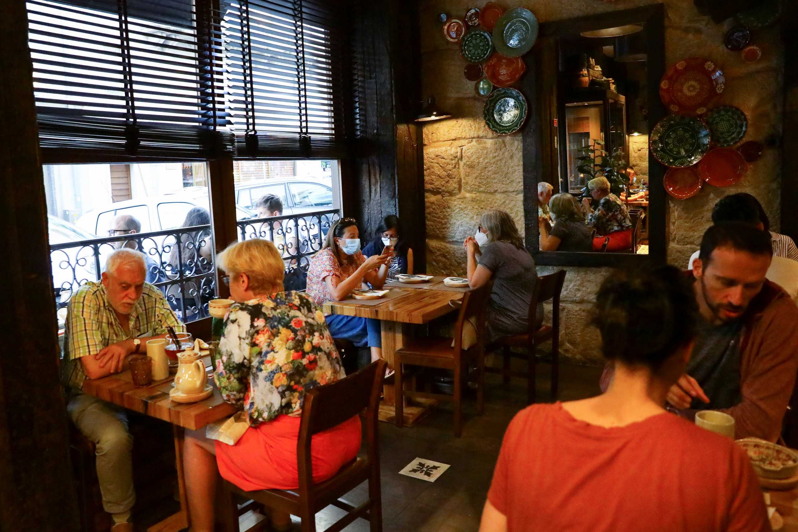 People dine at a restaurant, on the day that Portugal's government imposed stricter rules in an attempt to bring under control a surge of coronavirus disease (COVID-19) cases, in Porto, Portugal, July 10, 2021. REUTERS