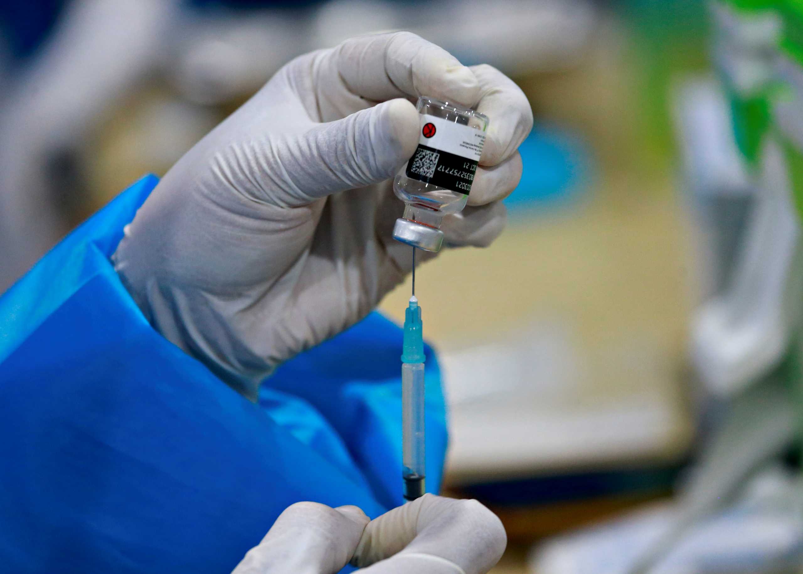 A healthcare worker prepares a dose of China's Sinovac Biotech vaccine against the coronavirus disease (COVID-19) during a mass vaccination program for domestic flight passengers, at Soekarno-Hatta International Airport in Tangerang, near Jakarta, Indonesia, July 6, 2021. REUTERS