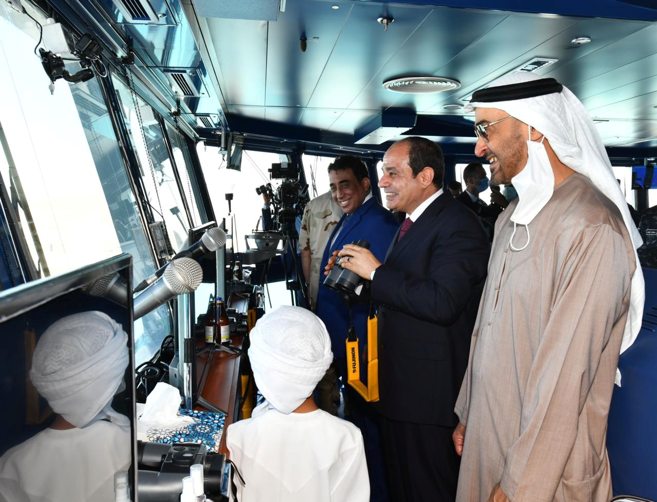 Egyptian President Abdel Fattah al-Sisi (C) stands next to Abu Dhabi's Crown Prince Sheikh Mohammed bin Zayed al-Nahyan (R) in a control tower during the inauguration of the new "July 3" naval base, in Marsa Matruh Egypt, July 3, 2021. in this handout picture courtesy of the Egyptian Presidency. The Egyptian Presidency