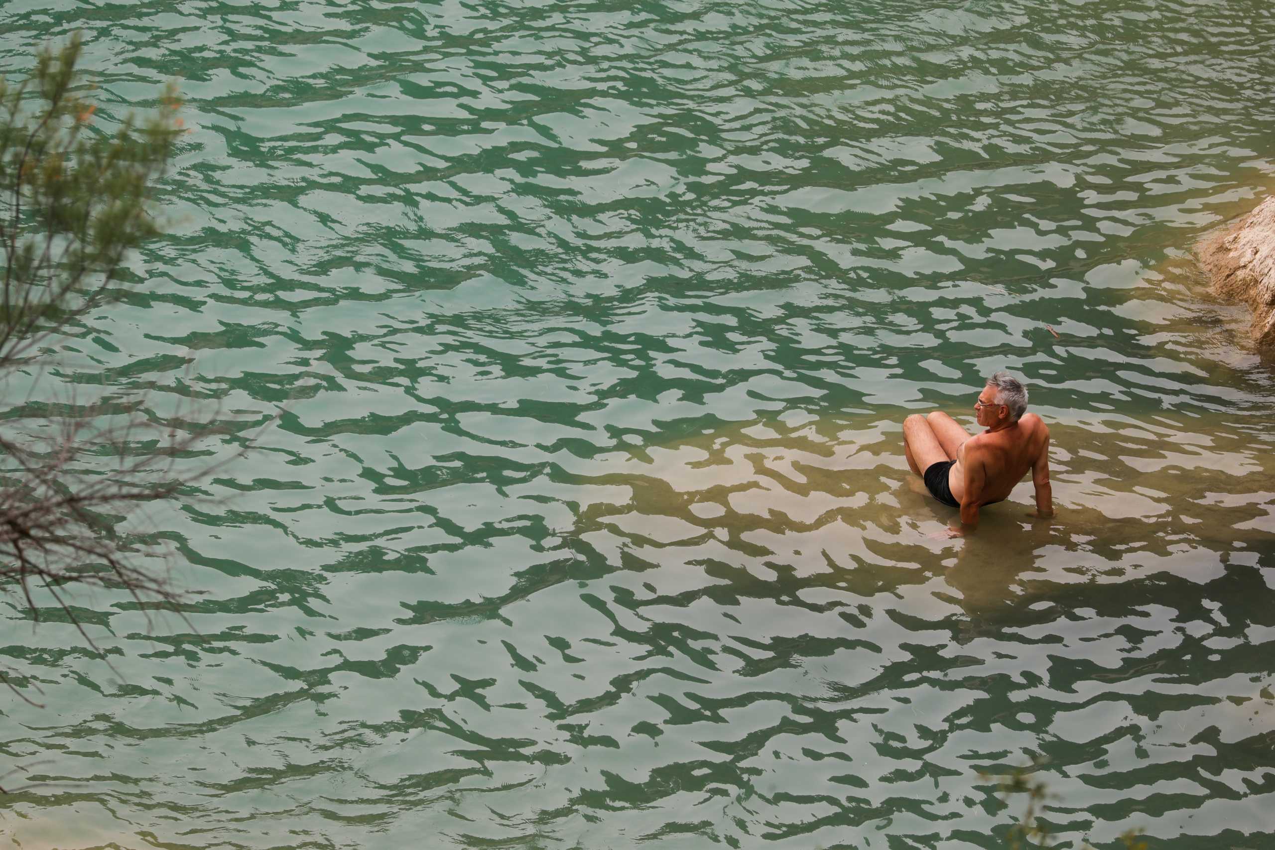 A man cools off at Conde del Guadalhorce reservoir as the summer's first heatwave hits the country, in El Chorro, near Ardales, Spain July 11, 2021. REUTERS