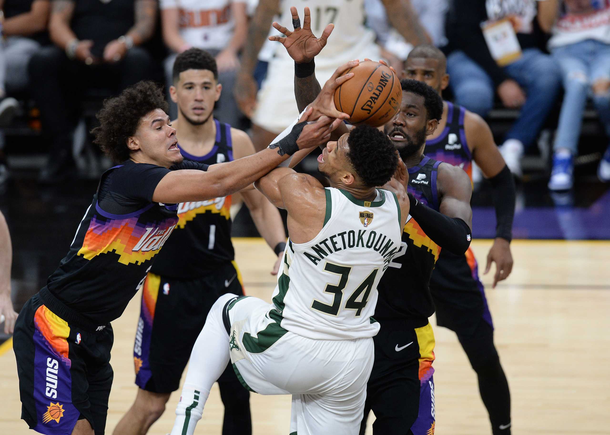 Jul 6, 2021; Phoenix, Arizona, USA; Milwaukee Bucks forward Giannis Antetokounmpo (34) is defended by Phoenix Suns forward Cameron Johnson (23) and center Deandre Ayton (22) during the second half in game one of the 2021 NBA Finals at Phoenix Suns Arena. Mandatory Credit: Joe Camporeale-USA TODAY Sports