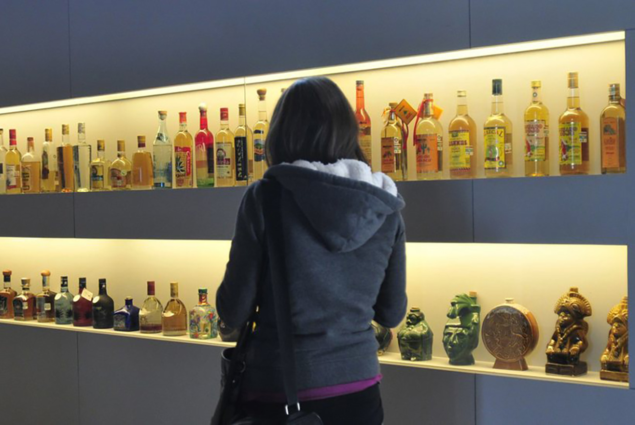 epa02539915 Picture made available on 20 January 2011 shows a woman observing bottles of tequila in Mexico City, Mexico, 14 December 2010. National production of Mexican tequila, the most popular drink in the country, rose in 2010 3,37 percent compared with 2009, and reached 257 million liters.  EPA