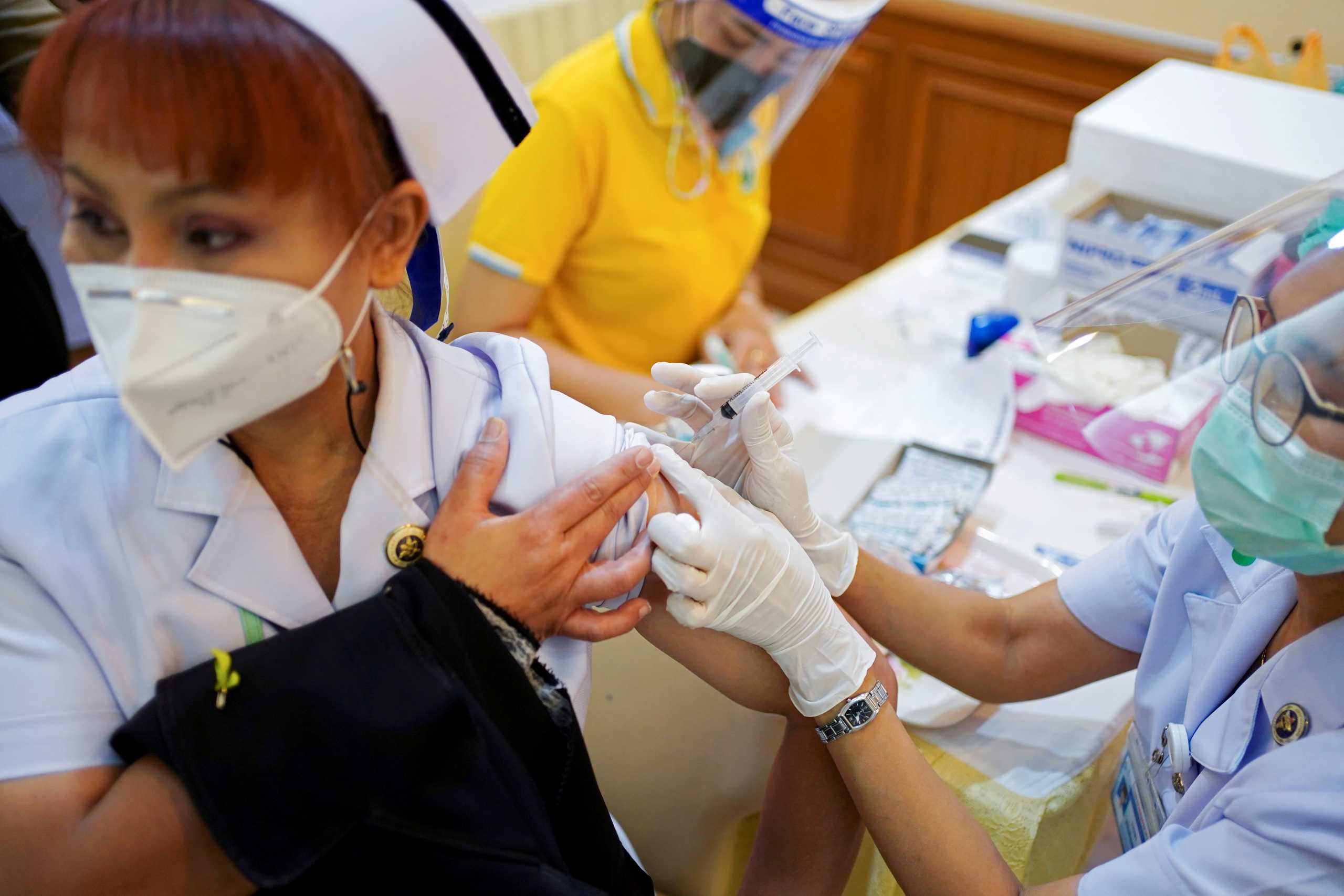 FILE PHOTO: A health worker receives the Sinovac coronavirus disease (COVID-19) vaccine at the Samut Sakhon hospital in Samut Sakhon province, Thailand, February 28, 2021. REUTERS