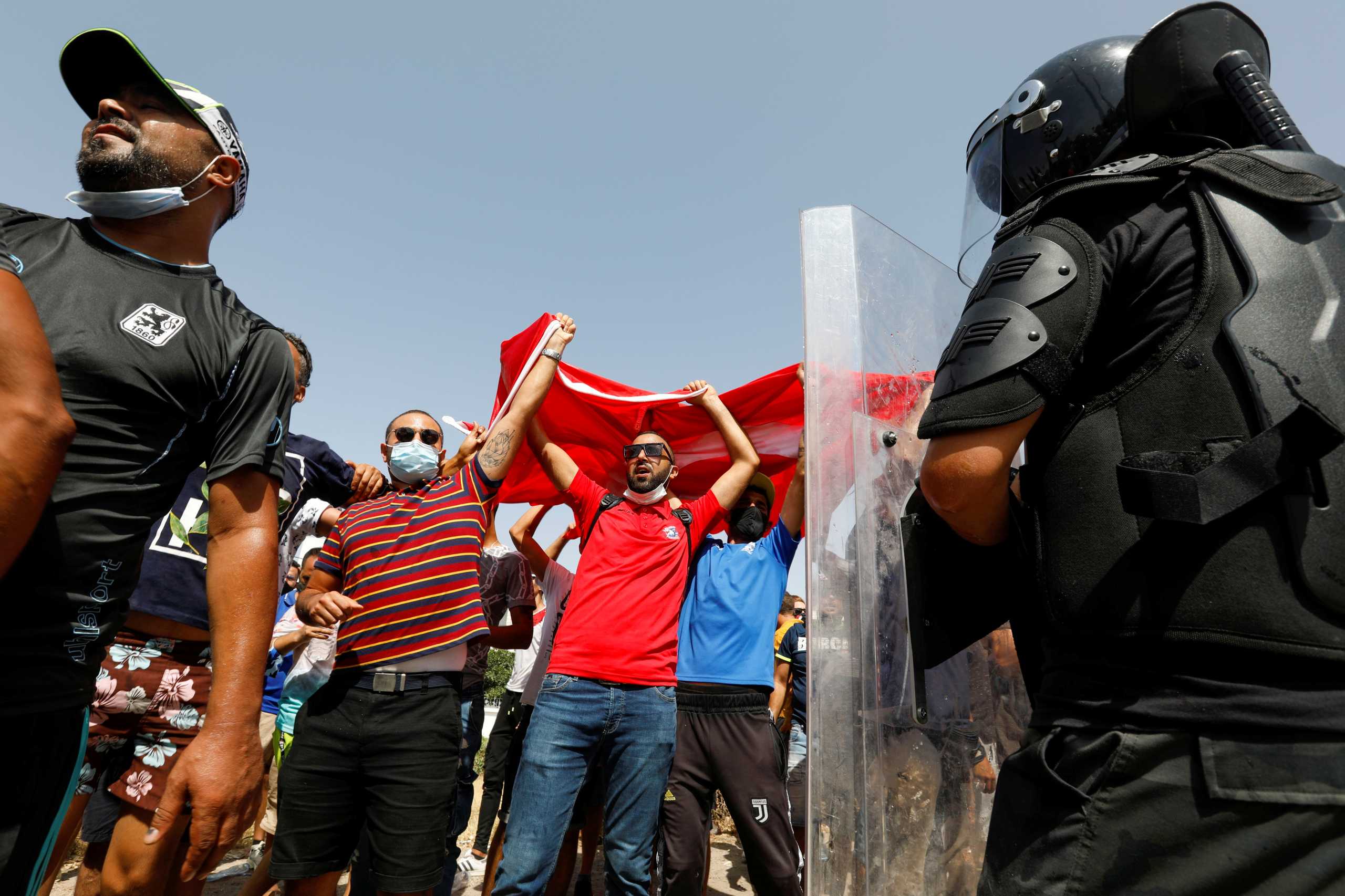 Supporters of Tunisia's President Kais Saied gather as a police officer stands guard near the parliament building in Tunis, Tunisia, July 26, 2021. REUTERS