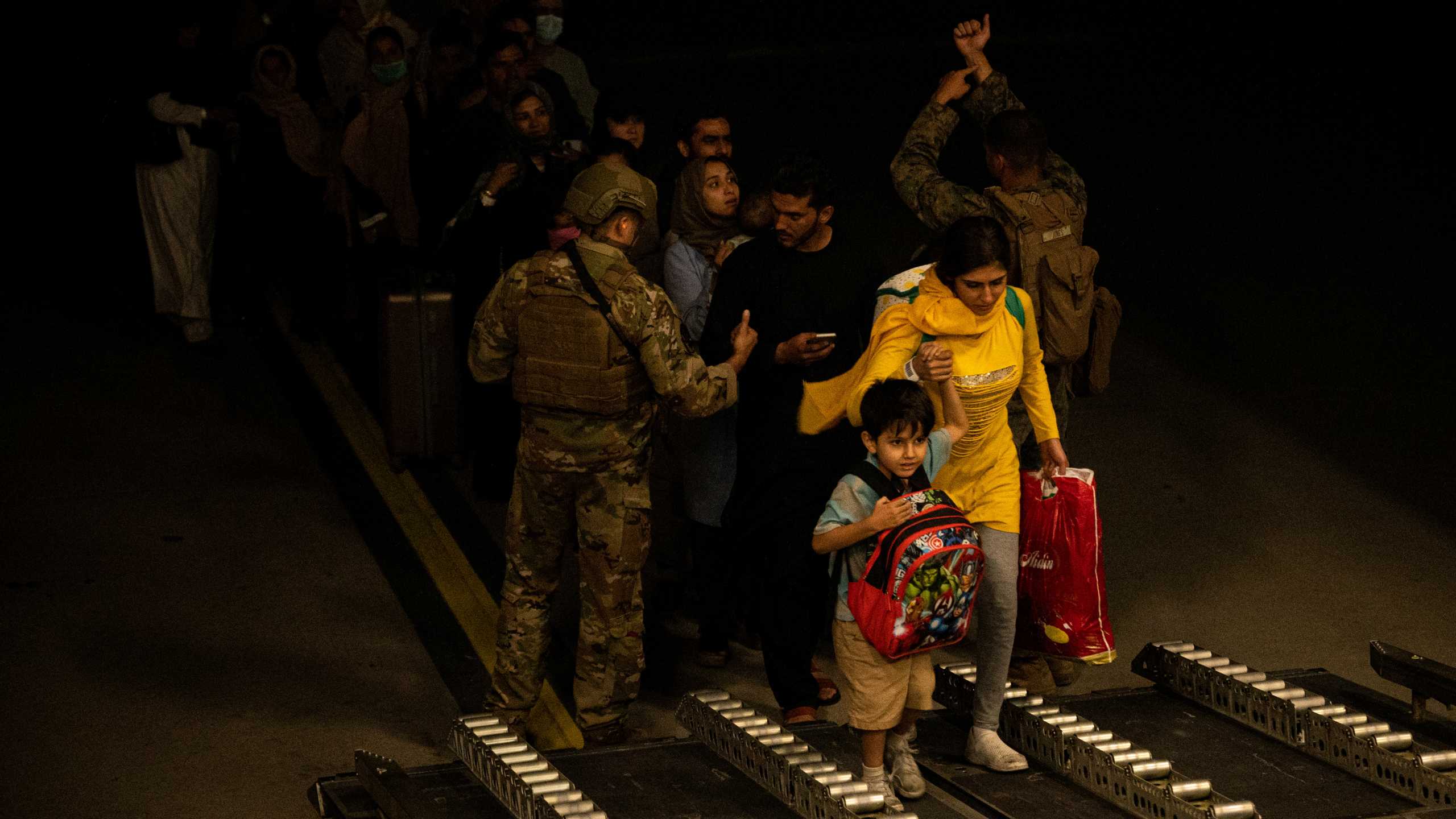 Evacuees from Afghanistan board a military aircraft during an evacuation from Kabul, in this photo taken on August 19, 2021 at undisclosed location and released on August 20, 2021.  Staff Sgt. Brandon Cribelar