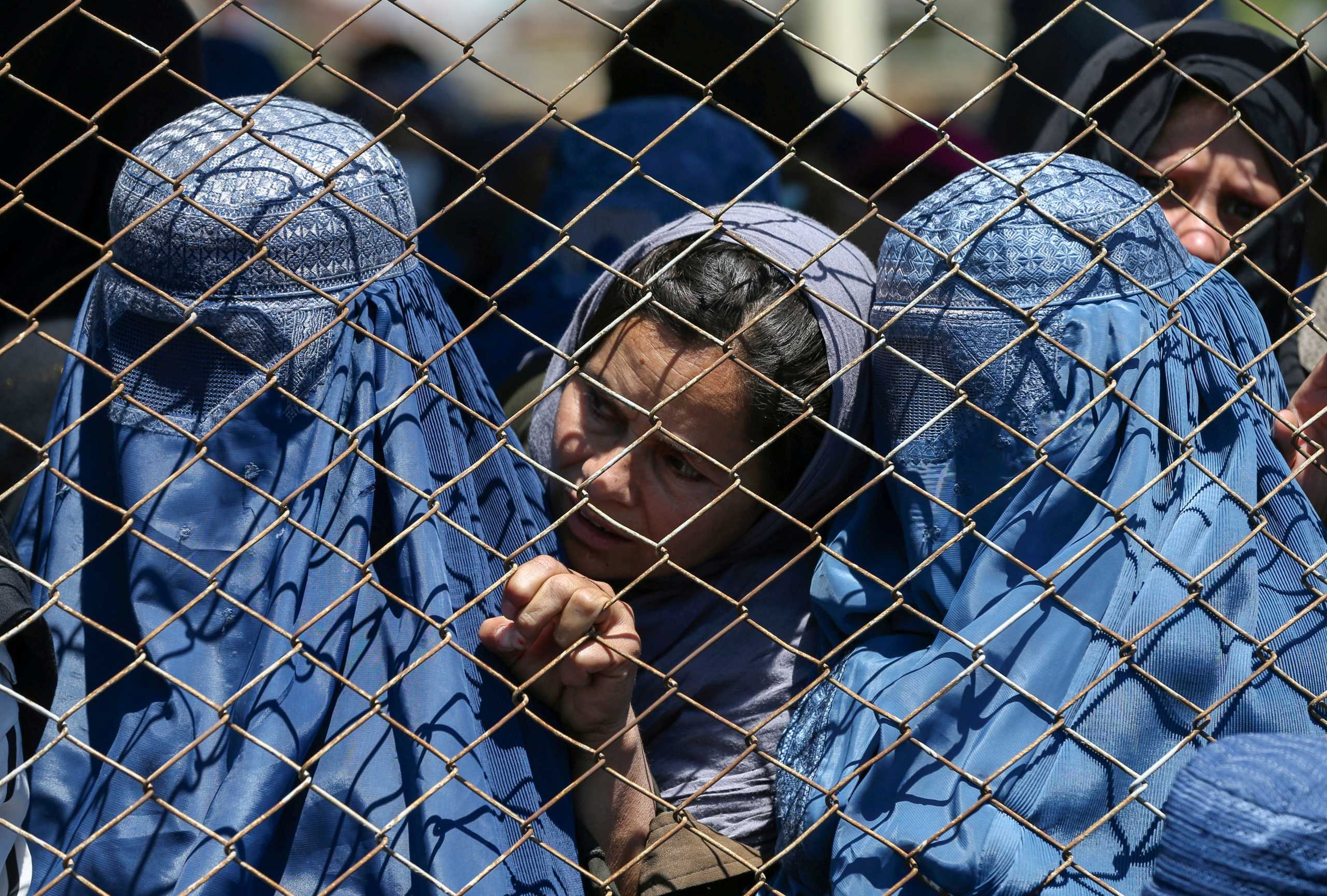 FILE PHOTO: Afghan women wait to receive free wheat donated by the Afghan government during a quarantine, amid concerns about the coronavirus disease (COVID-19) in Kabul, Afghanistan April 21, 2020. REUTERS