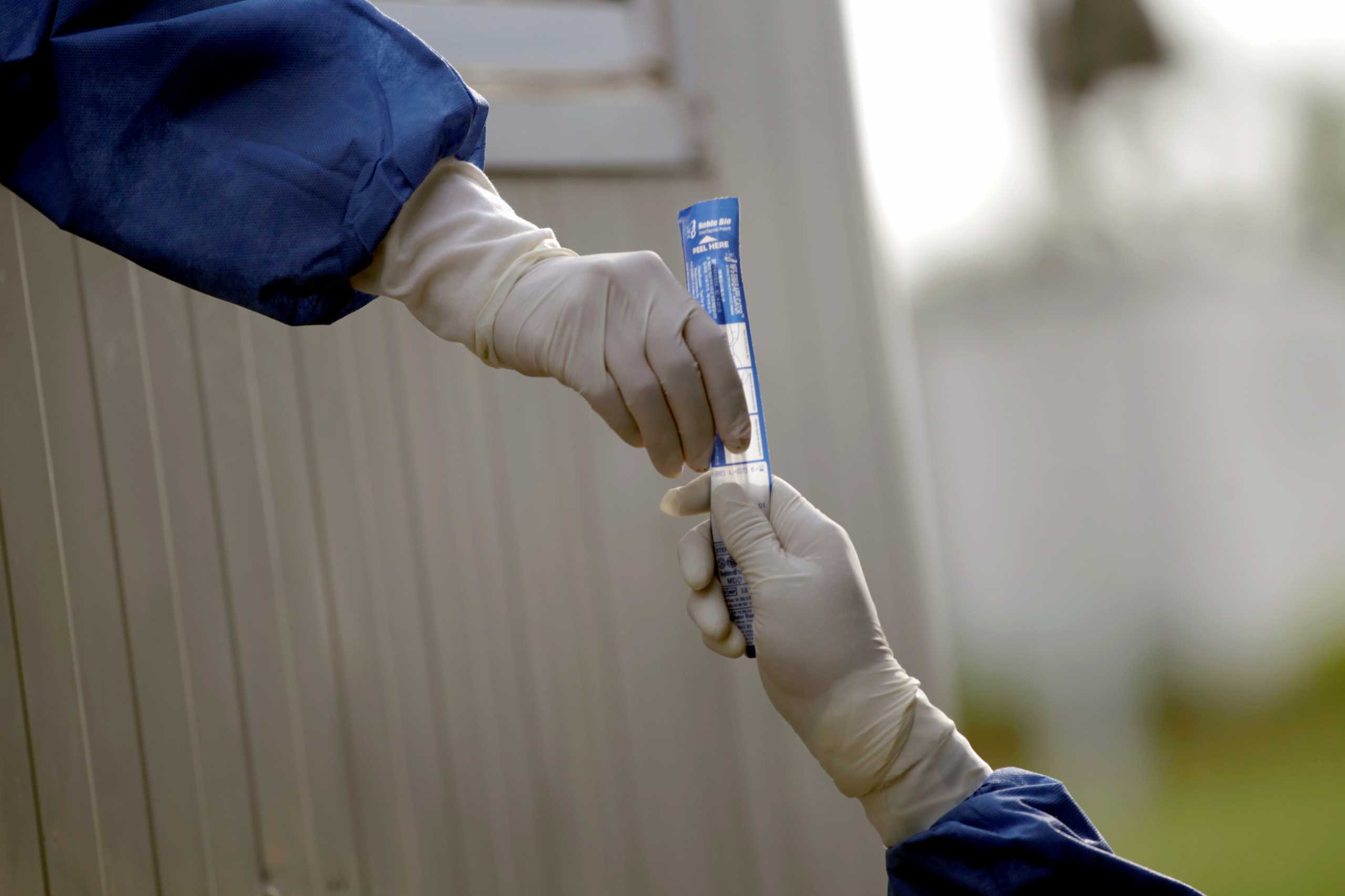 Medical workers handle a swab test before testing a driver as the coronavirus disease (COVID-19) continues, at a drive-thru testing site in Escobedo, on the outskirts of Monterrey, Mexico August 4, 2021. REUTERS