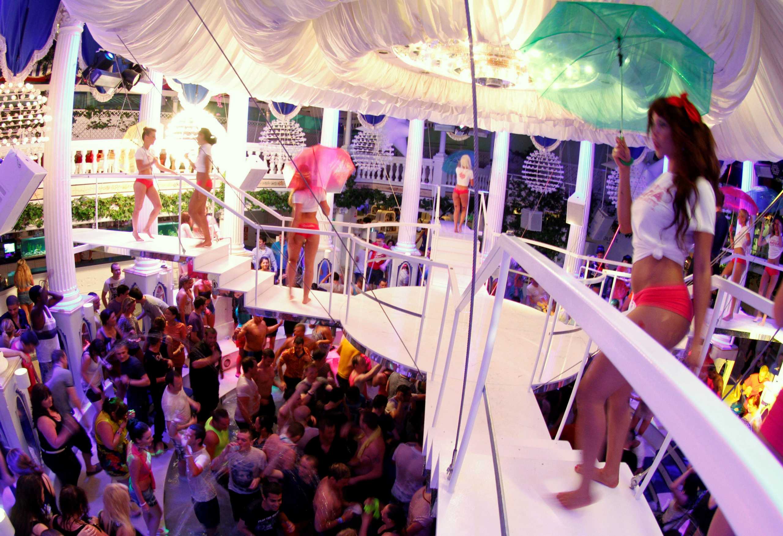 FILE PHOTO: Dancers perform over the crowd during a water party inside Paradis disco in San Antonio in the Spanish Balearic island of Ibiza early June 2, 2012. REUTERS