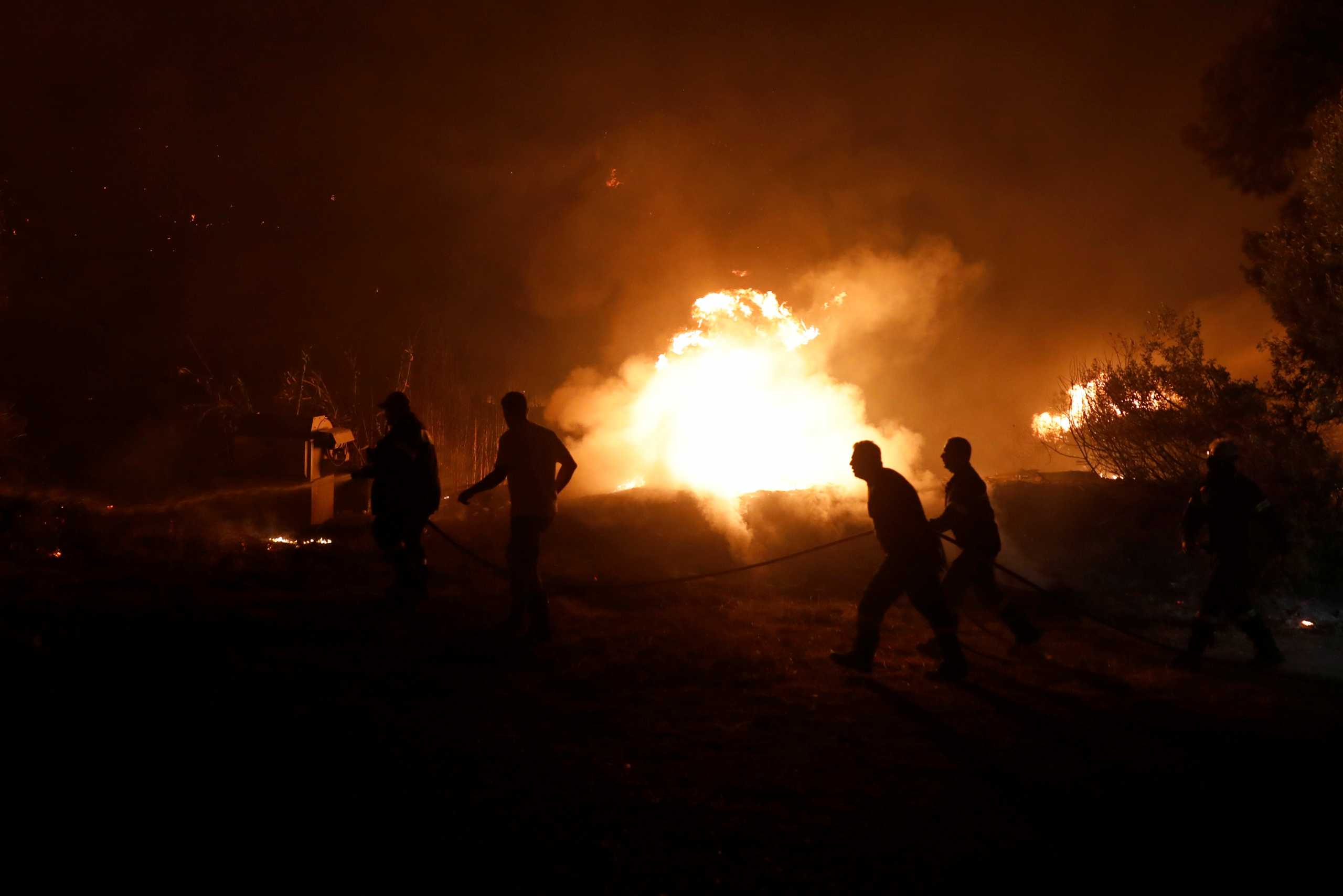 Firefighters try to extinguish a wildfire in the village of Rovies, on Evia island, Greece, August 4, 2021. REUTERS