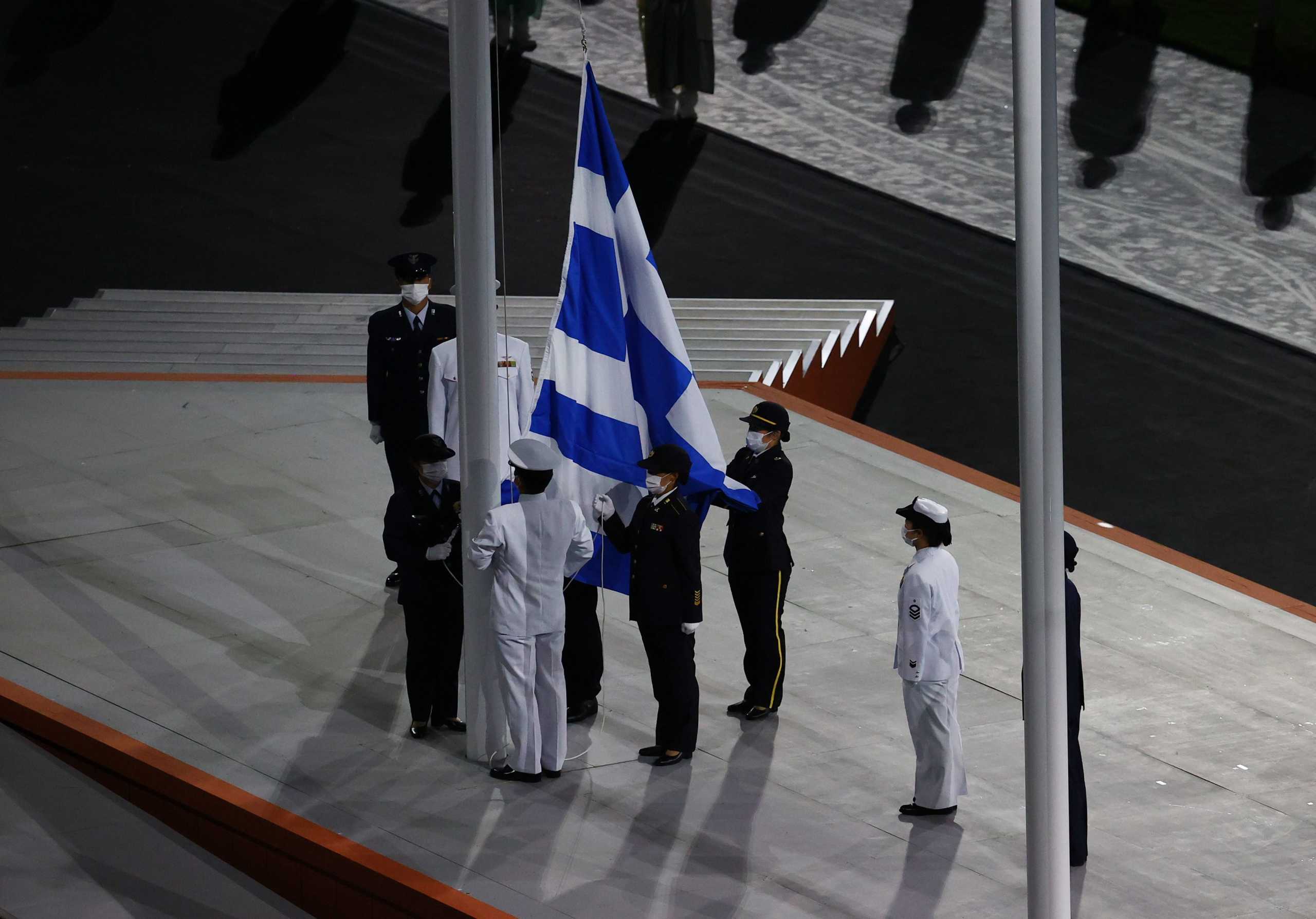 Tokyo 2020 Olympics - The Tokyo 2020 Olympics Closing Ceremony - Olympic Stadium, Tokyo, Japan - August 8, 2021. Officials raise the Greek flag during the ceremony REUTERS