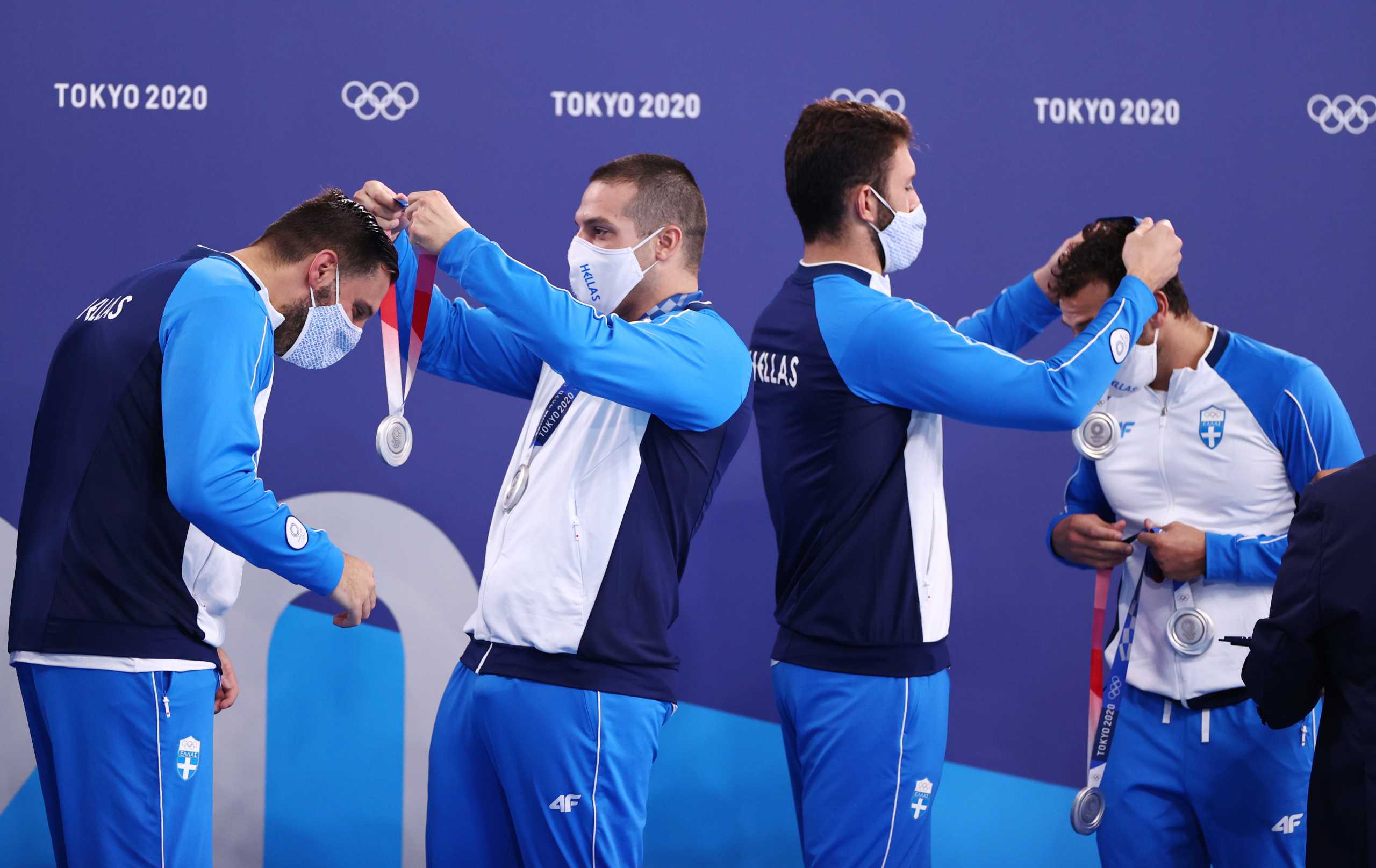 Tokyo 2020 Olympics - Water Polo - Men - Medal Ceremony - Tatsumi Water Polo Centre, Tokyo, Japan – August 8, 2021. Greece's team members, wearing face masks, receive their silver medals during medal ceremony REUTERS