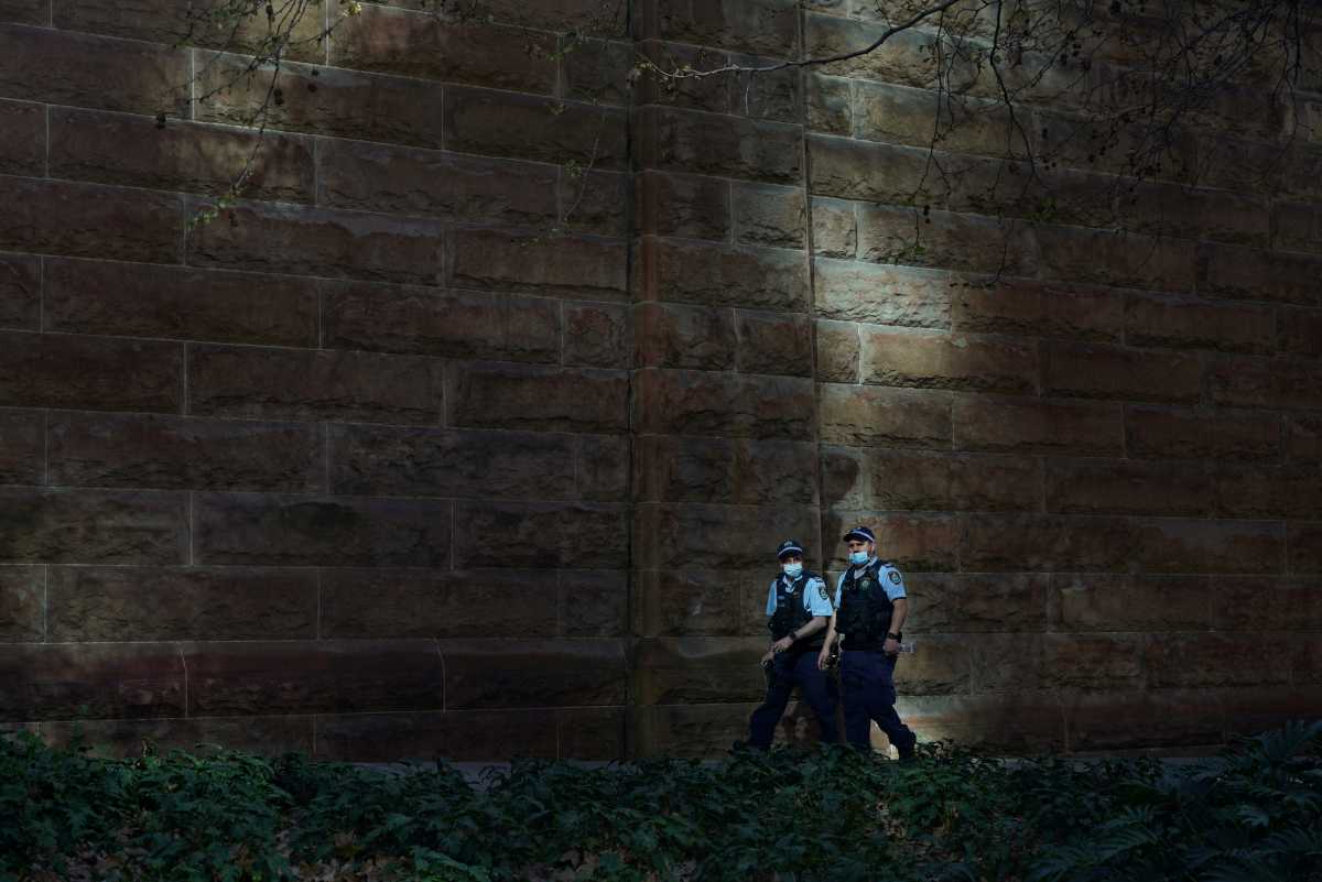 FILE PHOTO: Masked police officers patrol the quiet city centre during a lockdown to curb a coronavirus disease (COVID-19) outbreak in Sydney, Australia, August 20, 2021.  REUTERS