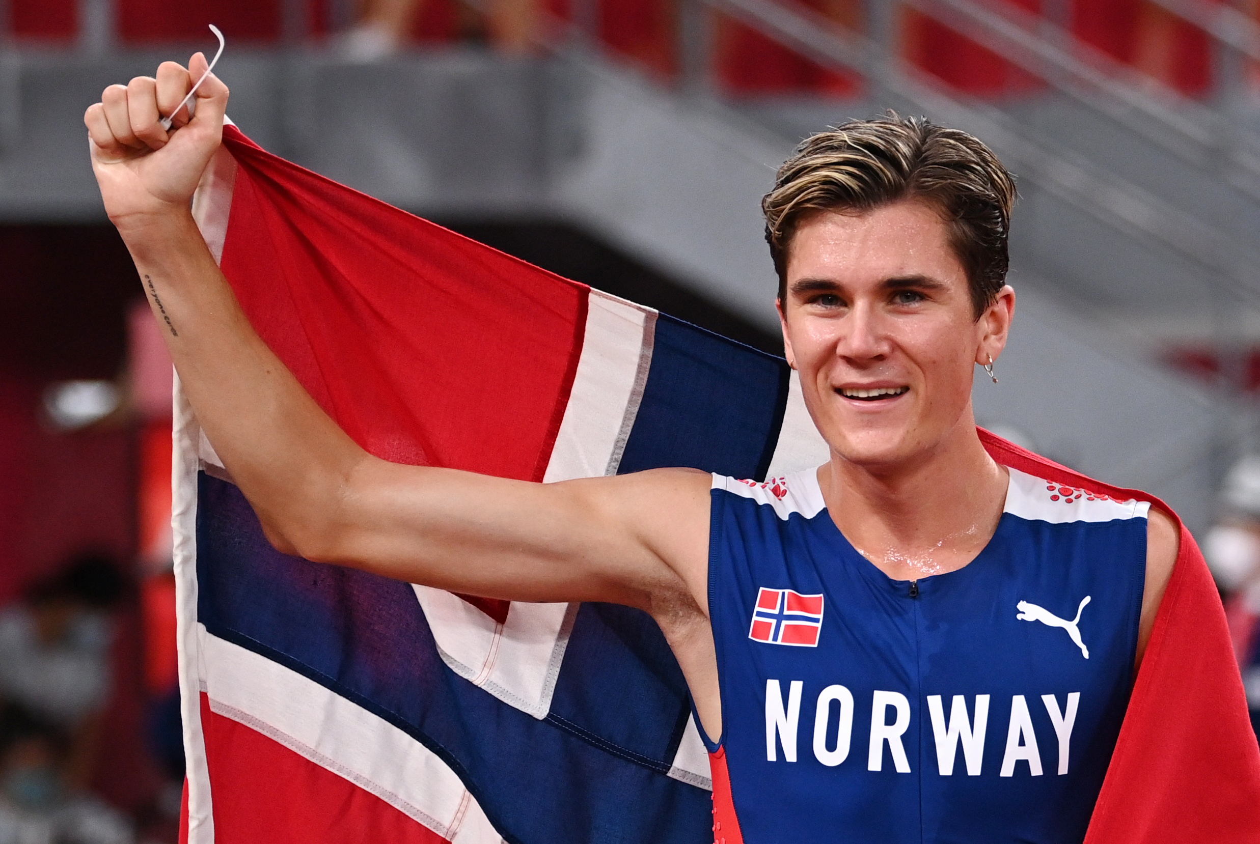 Tokyo 2020 Olympics - Athletics - Men's 1500m - Final - Olympic Stadium, Tokyo, Japan - August 7, 2021. Jakob Ingebrigtsen of Norway celebrates with his national flag after winning gold REUTERS