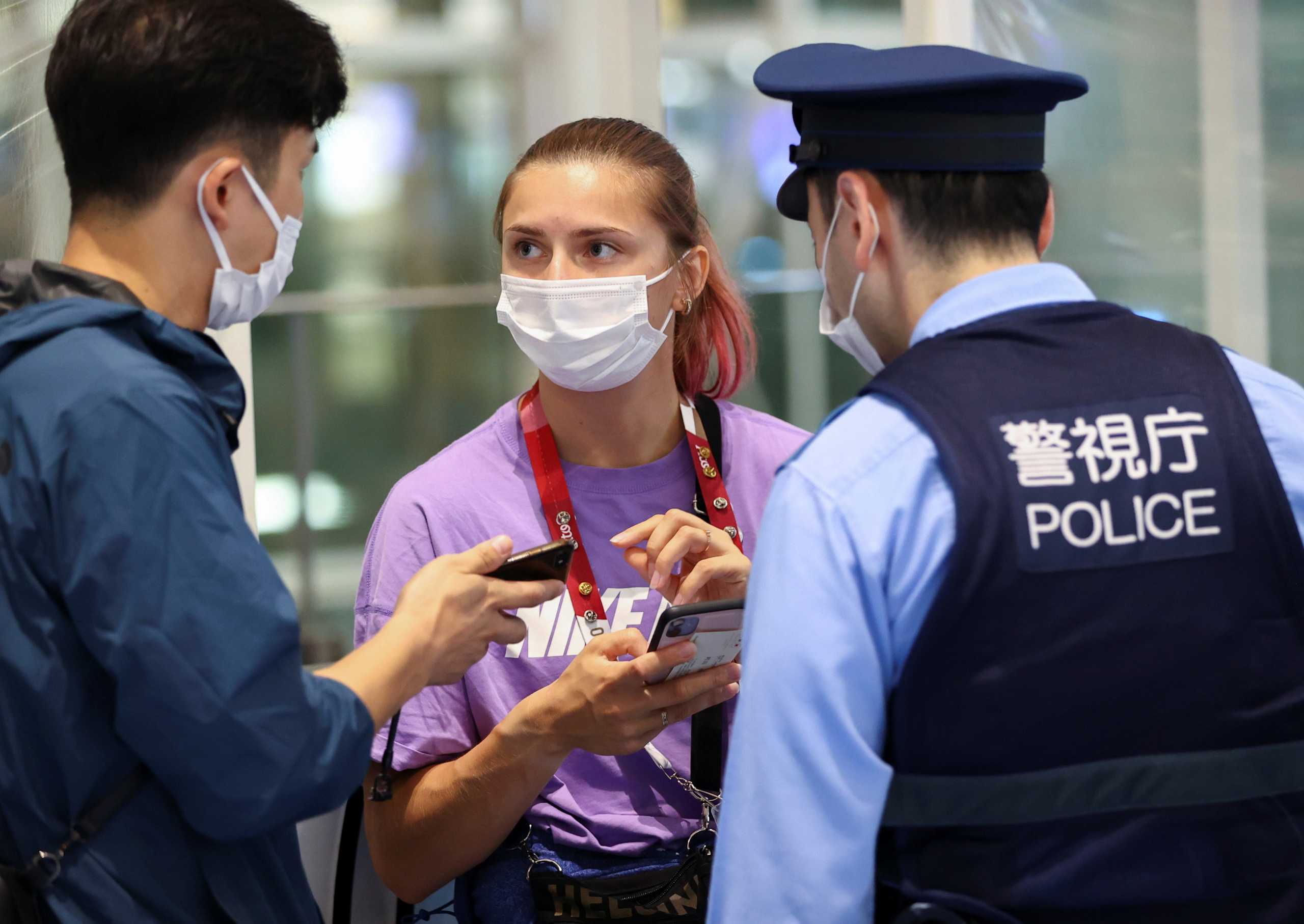 Belarusian athlete Krystsina Tsimanouskaya talks with a police officer at Haneda international airport in Tokyo, Japan August 1, 2021.  REUTERS