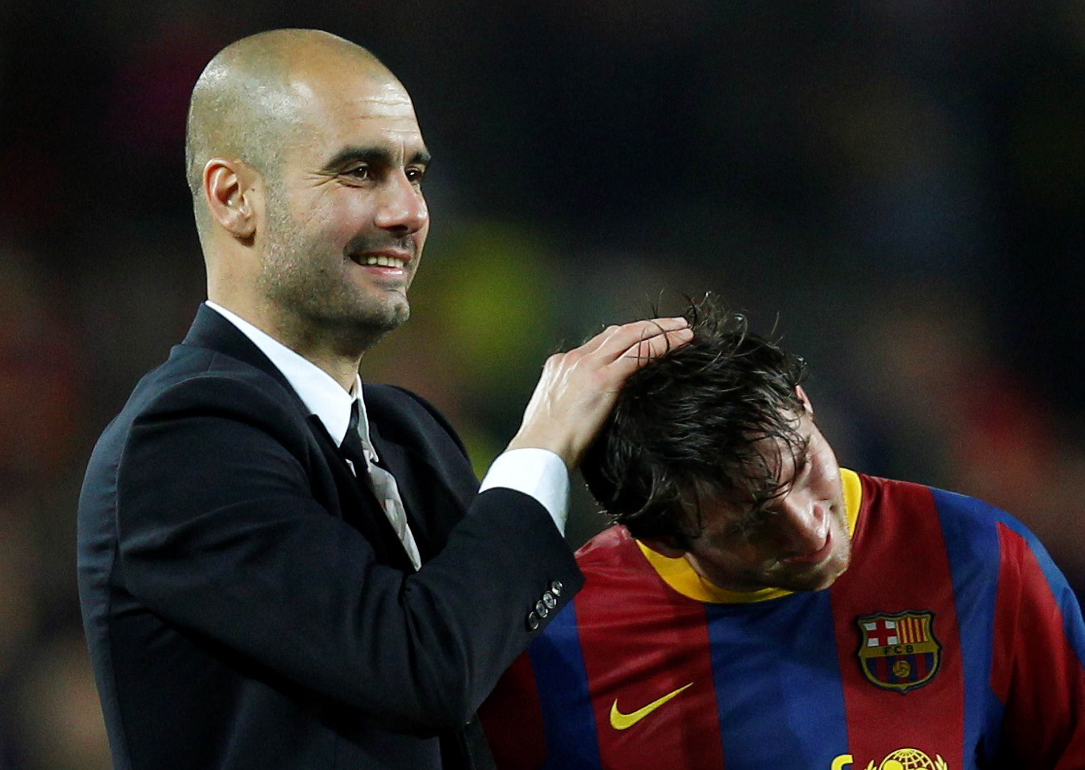 FILE PHOTO: Barcelona's coach Josep Guardiola (L) celebrates with Lionel Messi after qualifying for the final at the end of their Champions League semi-final second leg soccer match against Real Madrid at Nou Camp stadium in Barcelona, May 3, 2011.  REUTERS