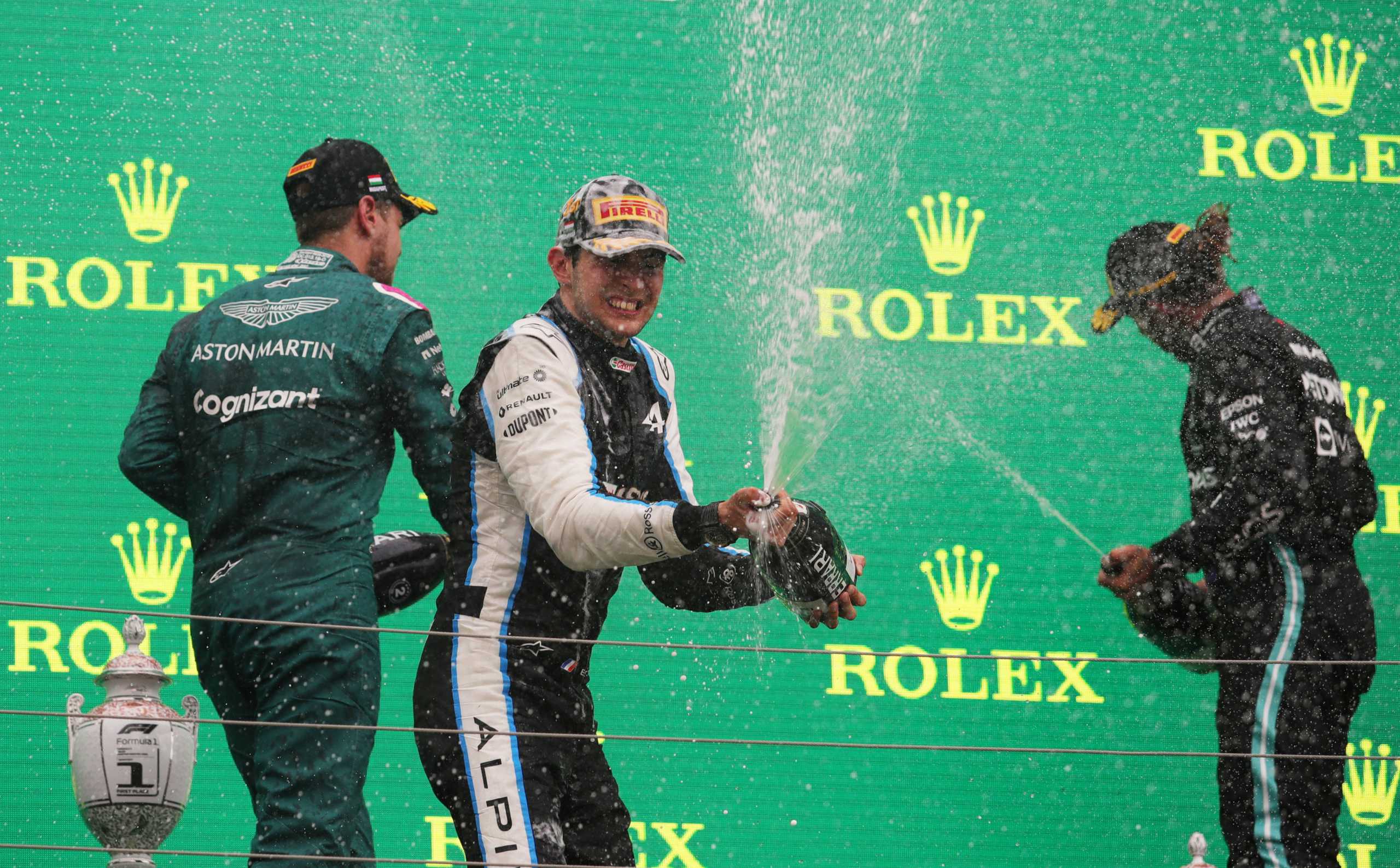 Formula One F1 - Hungarian Grand Prix - Hungaroring, Budapest, Hungary - August 1, 2021 Second placed Sebastian Vettel of Aston Martin, first placed Esteban Ocon of Alpine and third placed Lewis Hamilton of Mercedes celebrate on the podium after the race REUTERS