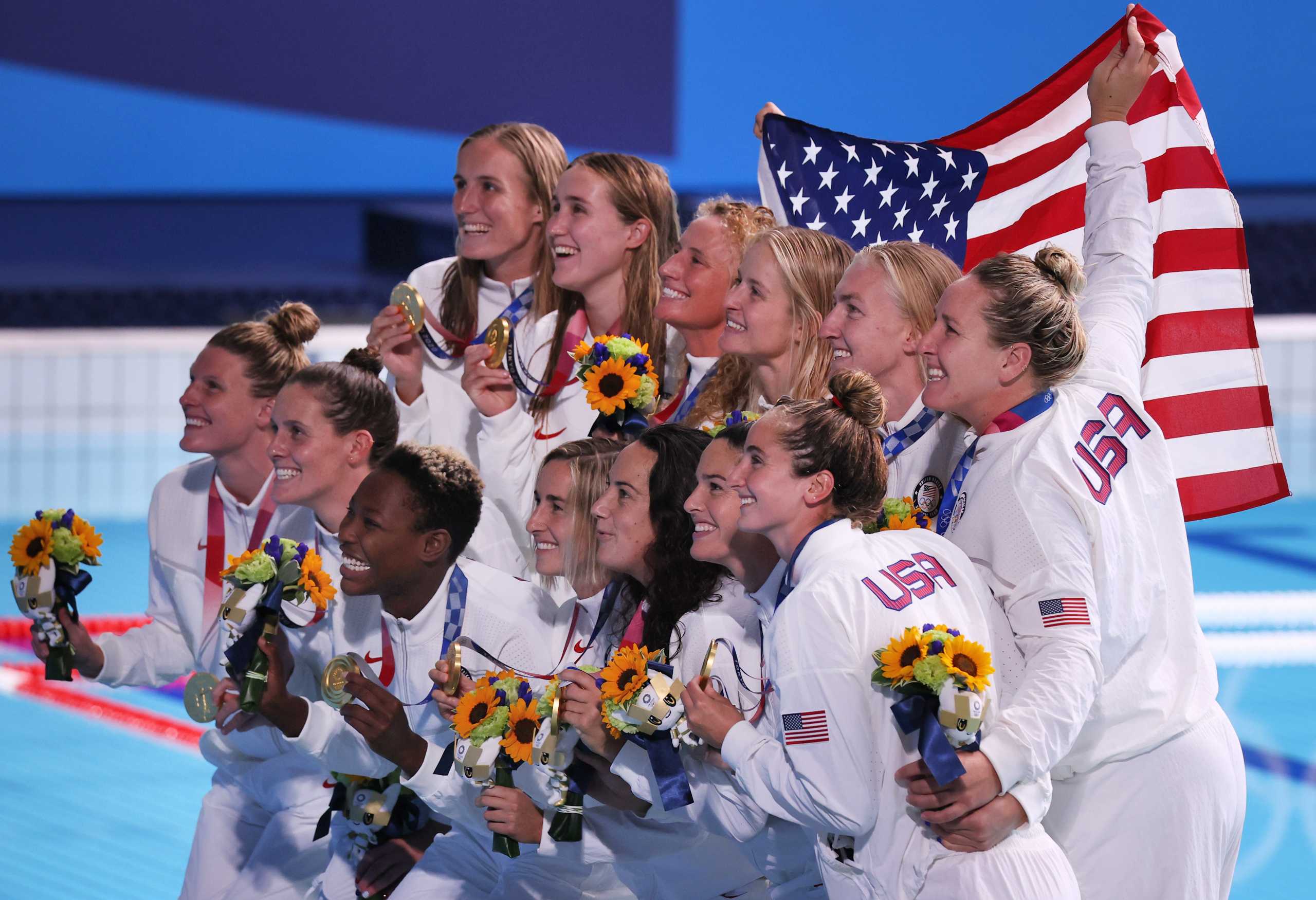 Tokyo 2020 Olympics - Water Polo - Women - Medal Ceremony - Tatsumi Water Polo Centre, Tokyo, Japan - August 7, 2021. United States' team members pose with their national flag as they celebrate winning gold REUTERS