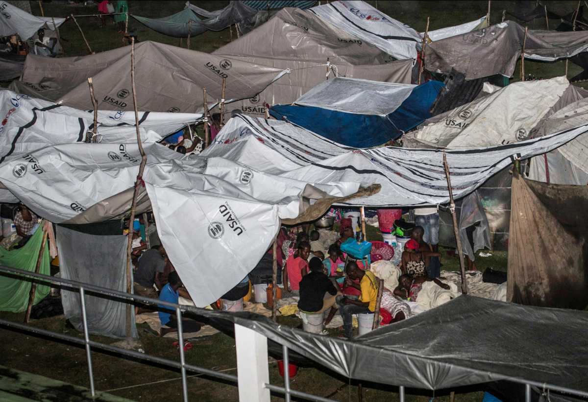 People who have lost their homes in a 7.2 magnitude quake sit under plastic sheets in a makeshift camp as tropical depression Grace passes through the area, in Les Cayes, Haiti August 16, 2021. Picture taken August 16, 2021. REUTERS