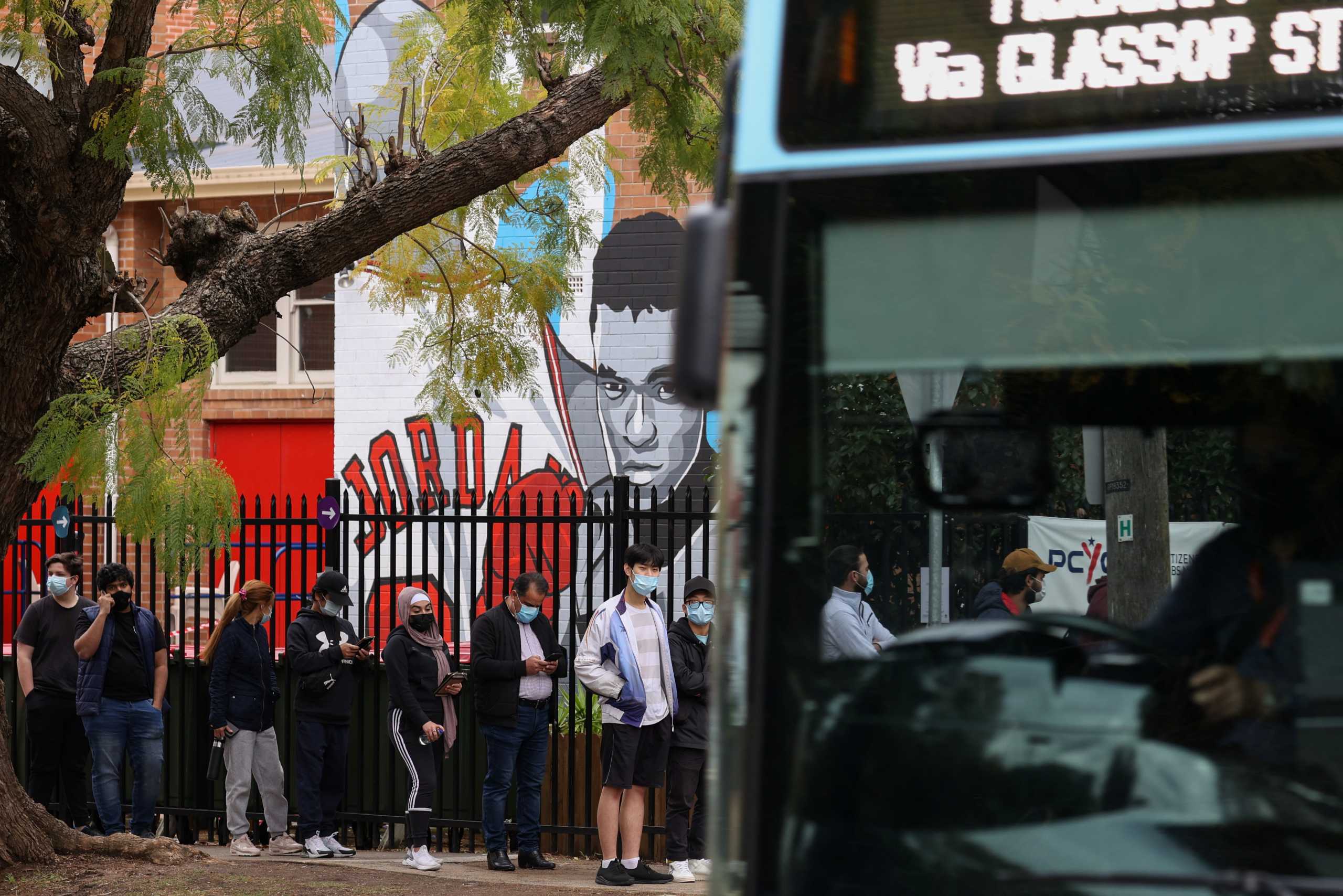 People wait in line outside a coronavirus disease (COVID-19) vaccination clinic in the Bankstown suburb during a lockdown to curb an outbreak of cases in Sydney, Australia, August 25, 2021.  REUTERS