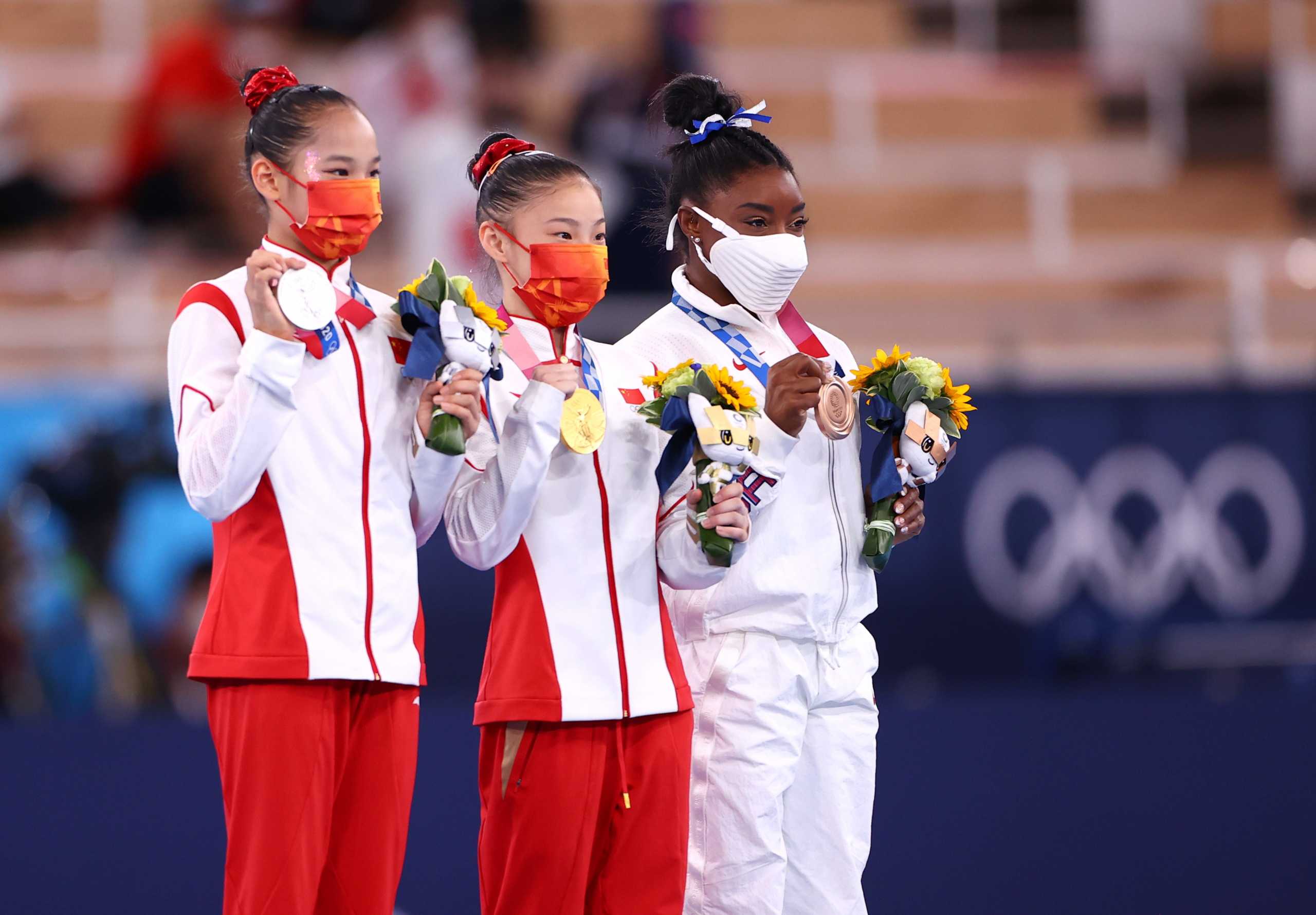 Tokyo 2020 Olympics - Gymnastics - Artistic - Women's Beam - Medal Ceremony - Ariake Gymnastics Centre, Tokyo, Japan - August 3, 2021. Gold medallist Guan Chenchen of China celebrates on the podium with silver medallist, Tang Xijing of China and bronze medallist, Simone Biles of the United States. REUTERS