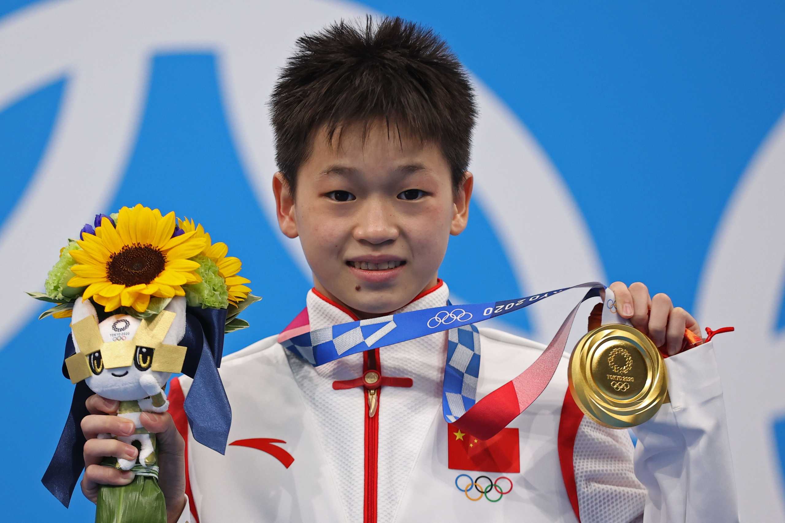 Tokyo 2020 Olympics - Diving - Women's 10m Platform - Medal Ceremony - Tokyo Aquatics Centre, Tokyo, Japan - August 5, 2021. Gold medallist Quan Hongchan of China poses with the bouquet and medal REUTERS