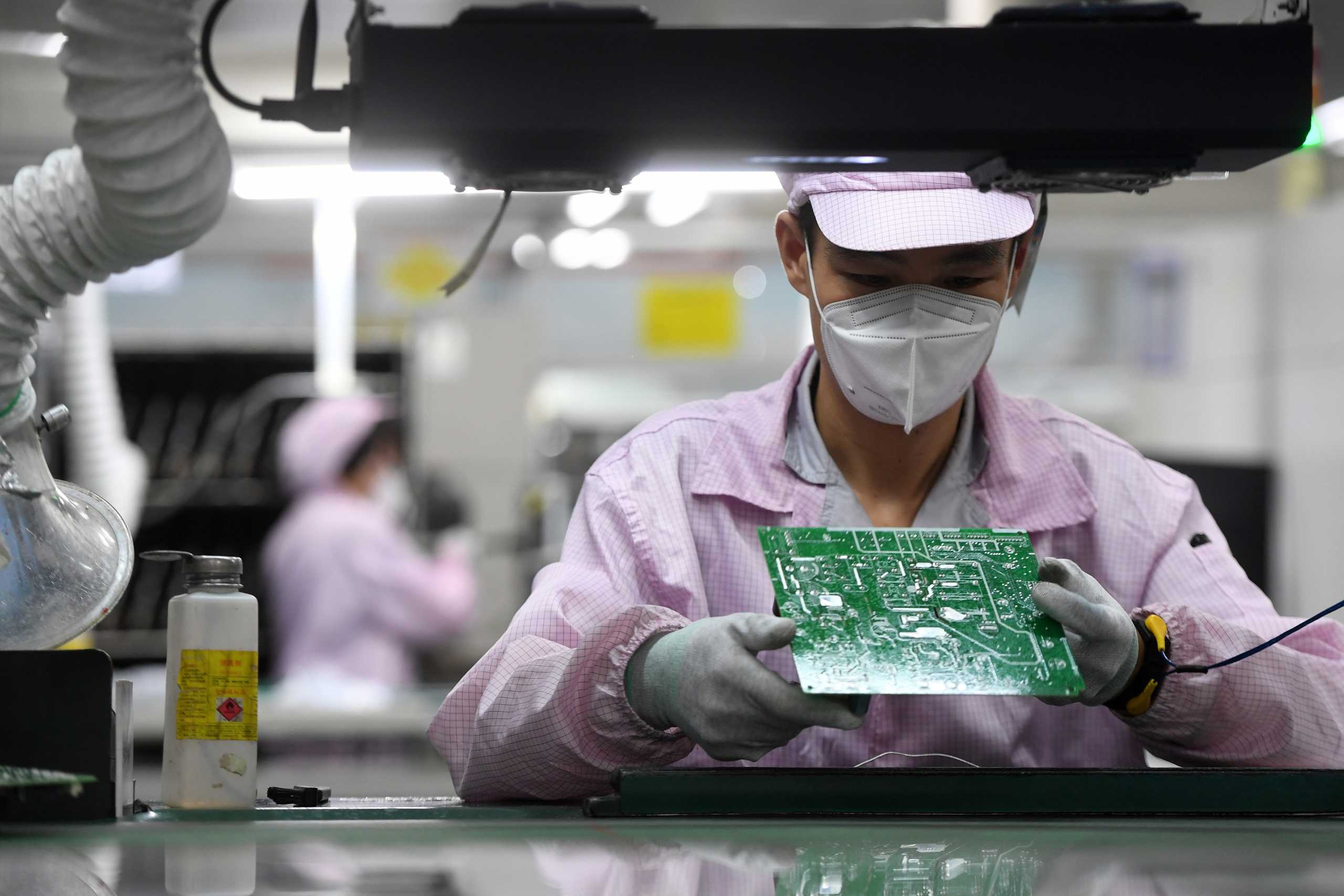 An employee inspects a circuit board on the controller production line at a Gree factory, following the coronavirus disease (COVID-19) outbreak in Wuhan, Hubei province, China August 16, 2021. China Daily via REUTERS  ATTENTION EDITORS - THIS IMAGE WAS PROVIDED BY A THIRD PARTY. CHINA OUT.