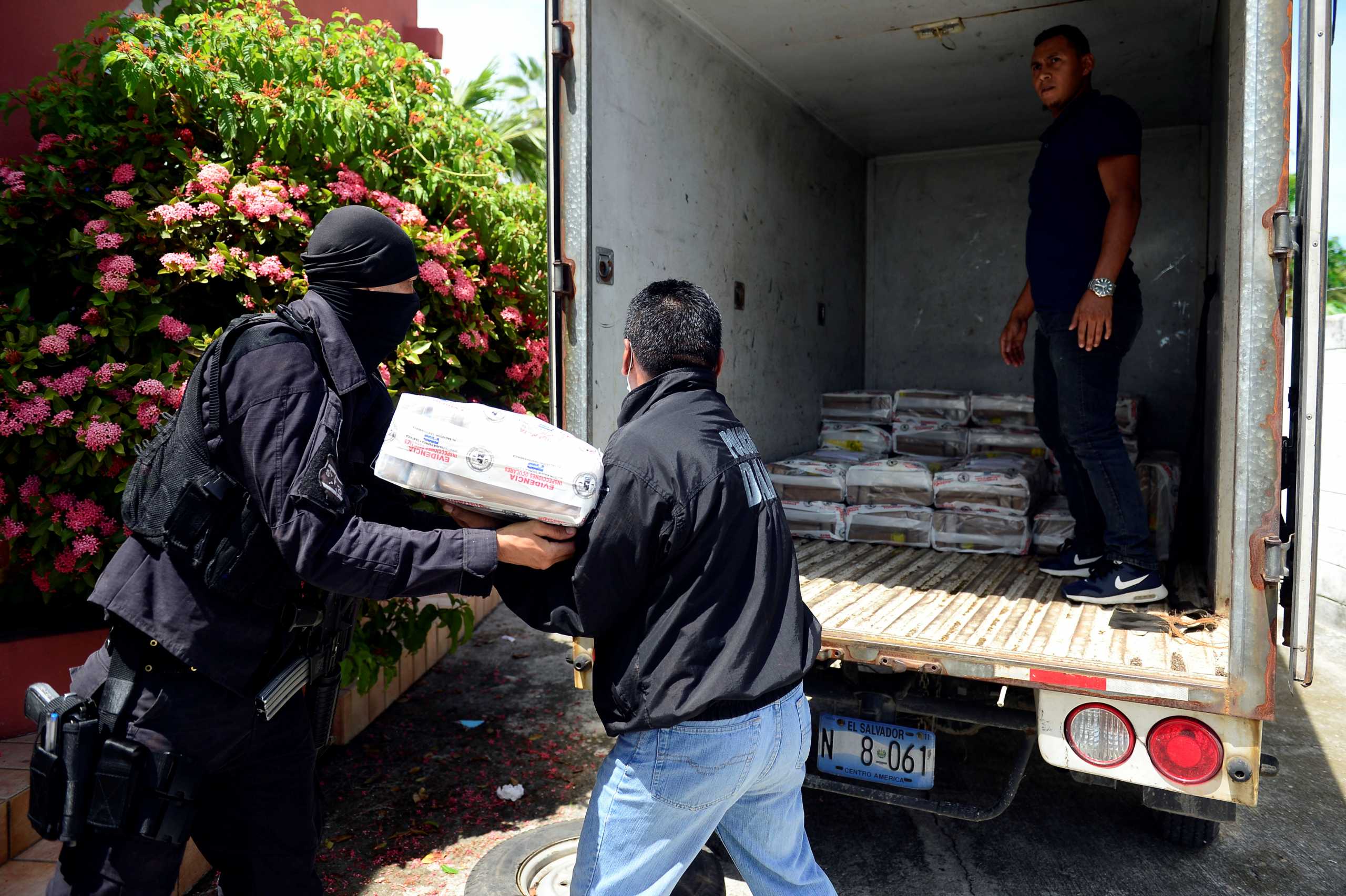 Police officers load packages of cocaine onto a truck, part of a high seas drug seizure of 1.4 tons of cocaine by Salvadoran Naval Force, at a base in San Luis la Herradura, El Salvador August 5, 2021. REUTERS