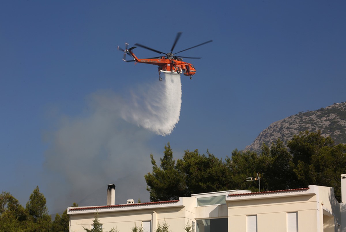 Ελικόπτερο της πυροσβεστικής επιχειρεί στην κατάσβεση της πυρκαγιάς στην περιοχή των Θρακομακεδόνων, Σάββατο 07 Αυγούστου 2021. Εξαιρετικά δύσκολη ήταν η νύχτα για την Αττική, στην οποία συνεχίζεται ο εφιάλτης από την πυρκαγιά που έχει πάρει τεράστιες διαστάσεις στην Πάρνηθα, στον Άγιο Στέφανο και στην Μαλακάσα, ενώ προβλέπεται μια ακόμα πιο δύσκολη μέρα, καθώς άρχισε ήδη να ενισχύονται οι άνεμοι στην περιοχή. Στο μέτωπο της Πάρνηθας το πρόβλημα εντοπίζεται στους Θρακομακεδόνες και την Βαρυμπόμπη, όπου οι φλόγες είναι από χτες μέσα στους οικισμούς και έχουν κάψει σπίτια, ενώ οι ισχυρές επίγειες δυνάμεις έδωσαν τιτάνια μάχη για να ανακόψουν την πορεία της, αλλά δεν κατάφεραν να την ελέγξουν. ΑΠΕ-ΜΠΕ
